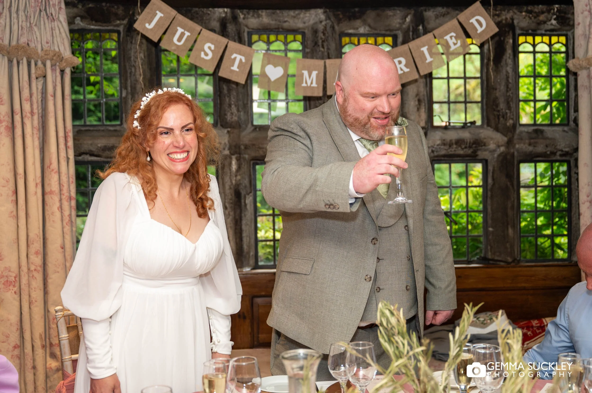 Bride and groom reacting during wedding speeches