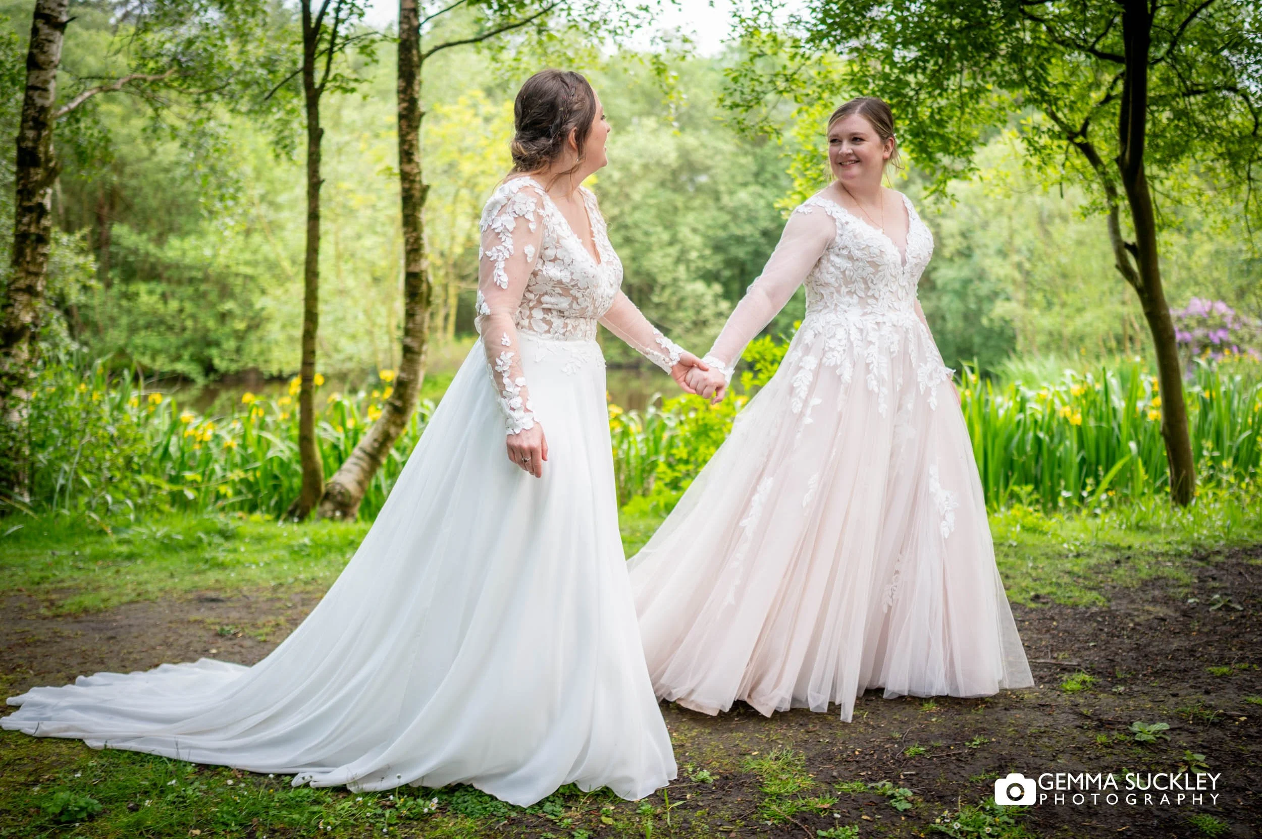 brides walking together in woodland during their portraits