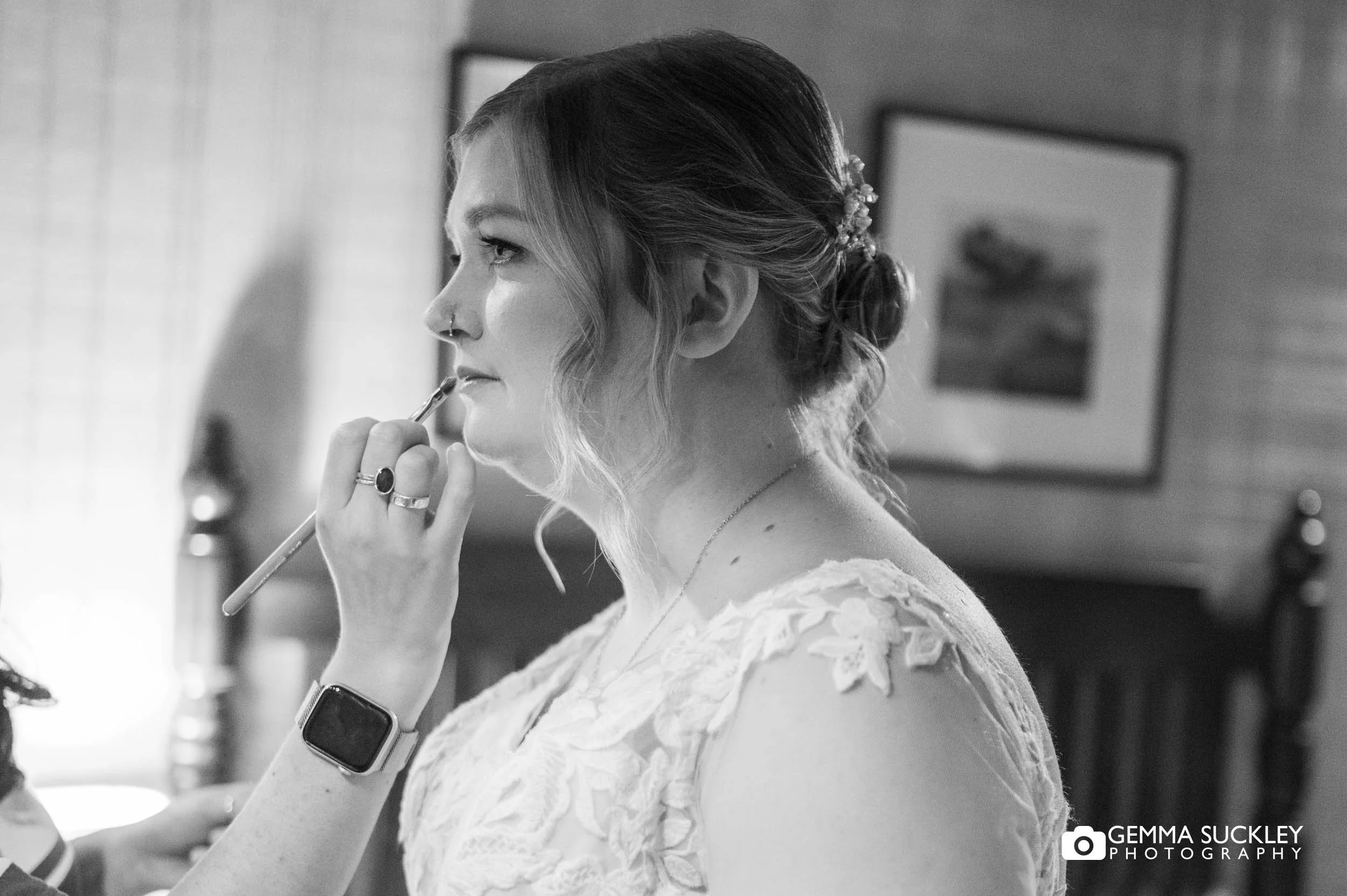 Bride having her makeup done before the ceremony