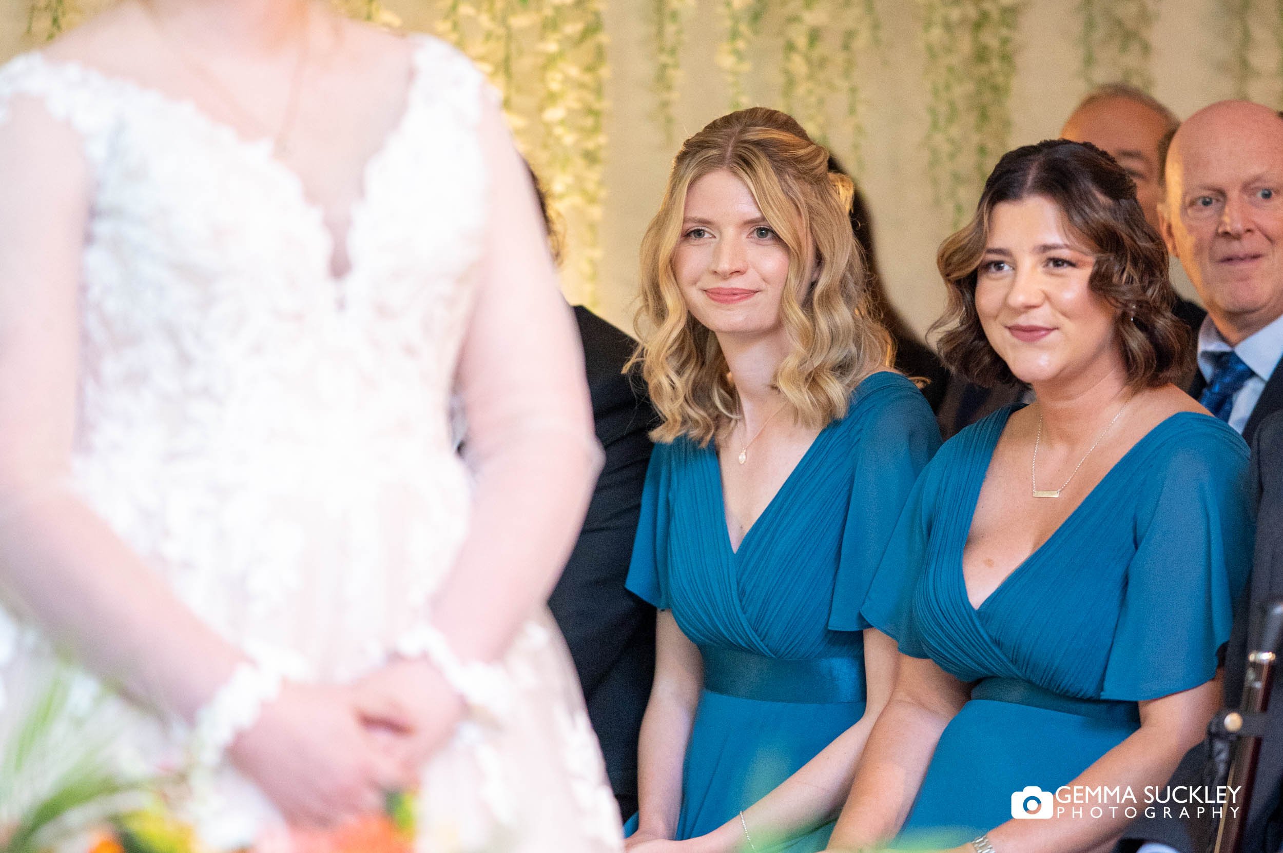 bridesmaids watching during same sex wedding ceremony