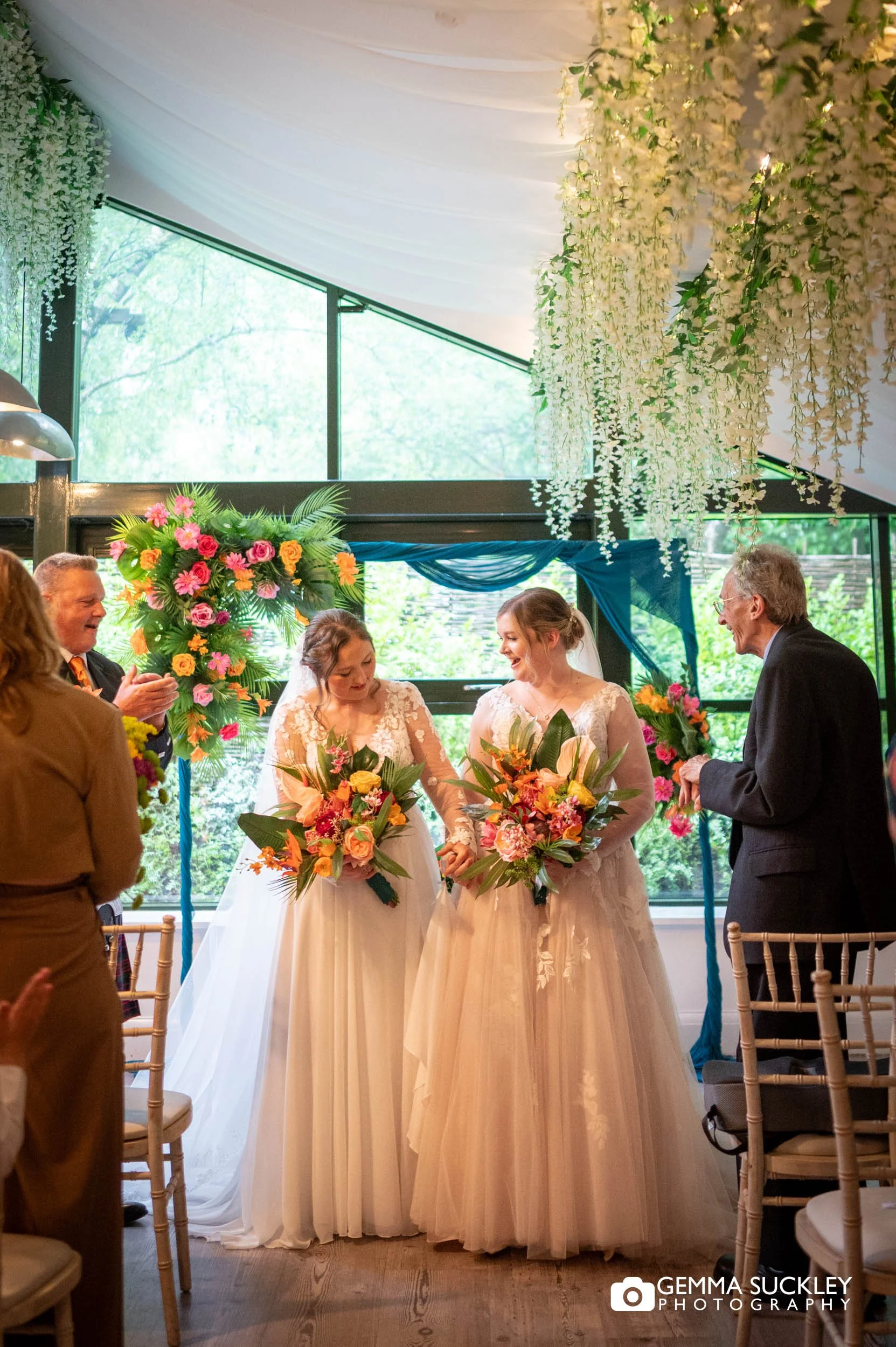 Guests cheering for the newlywed same-sex couple during the ceremony