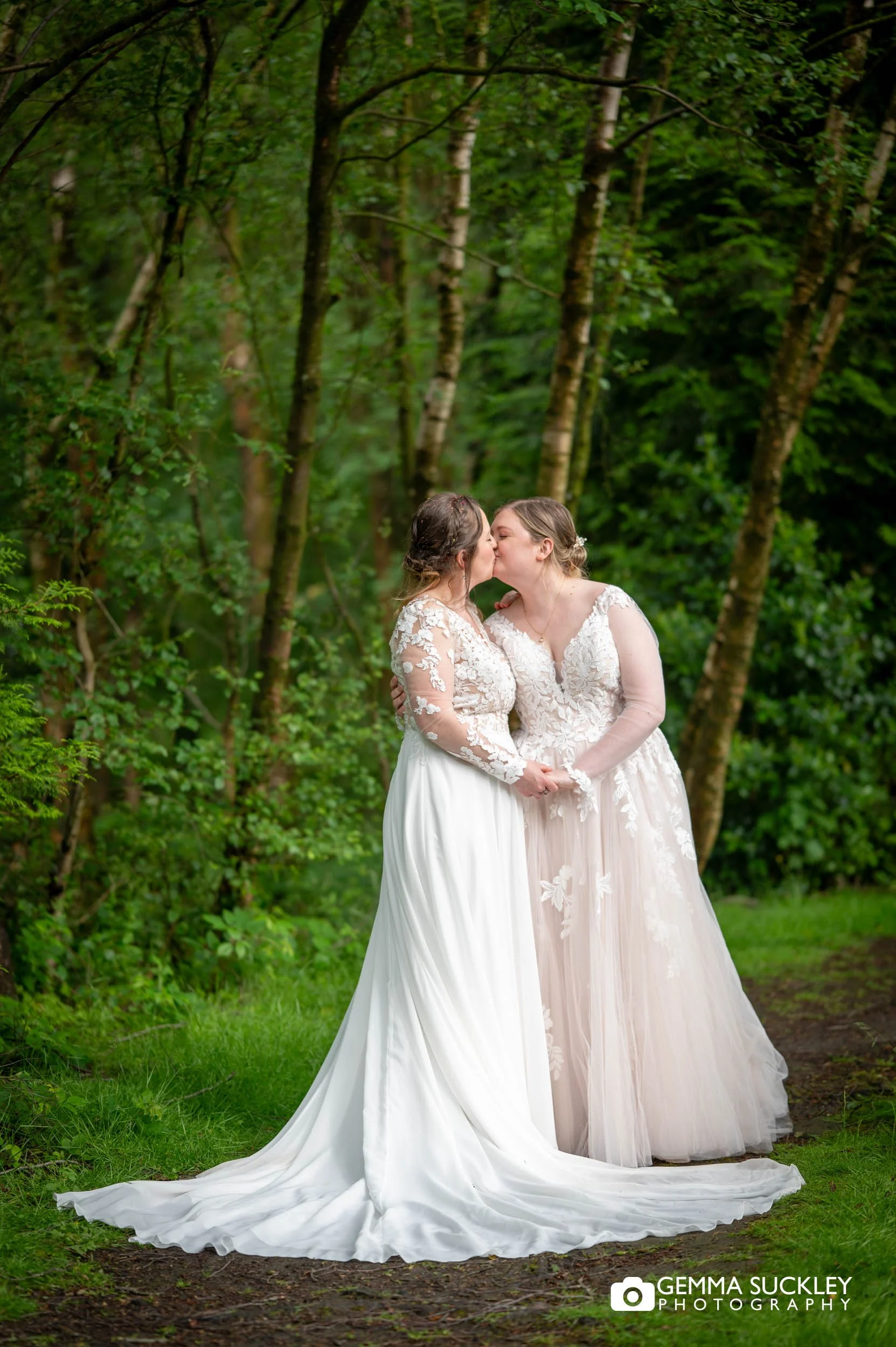 Bride and bride sharing a kiss during woodland portraits