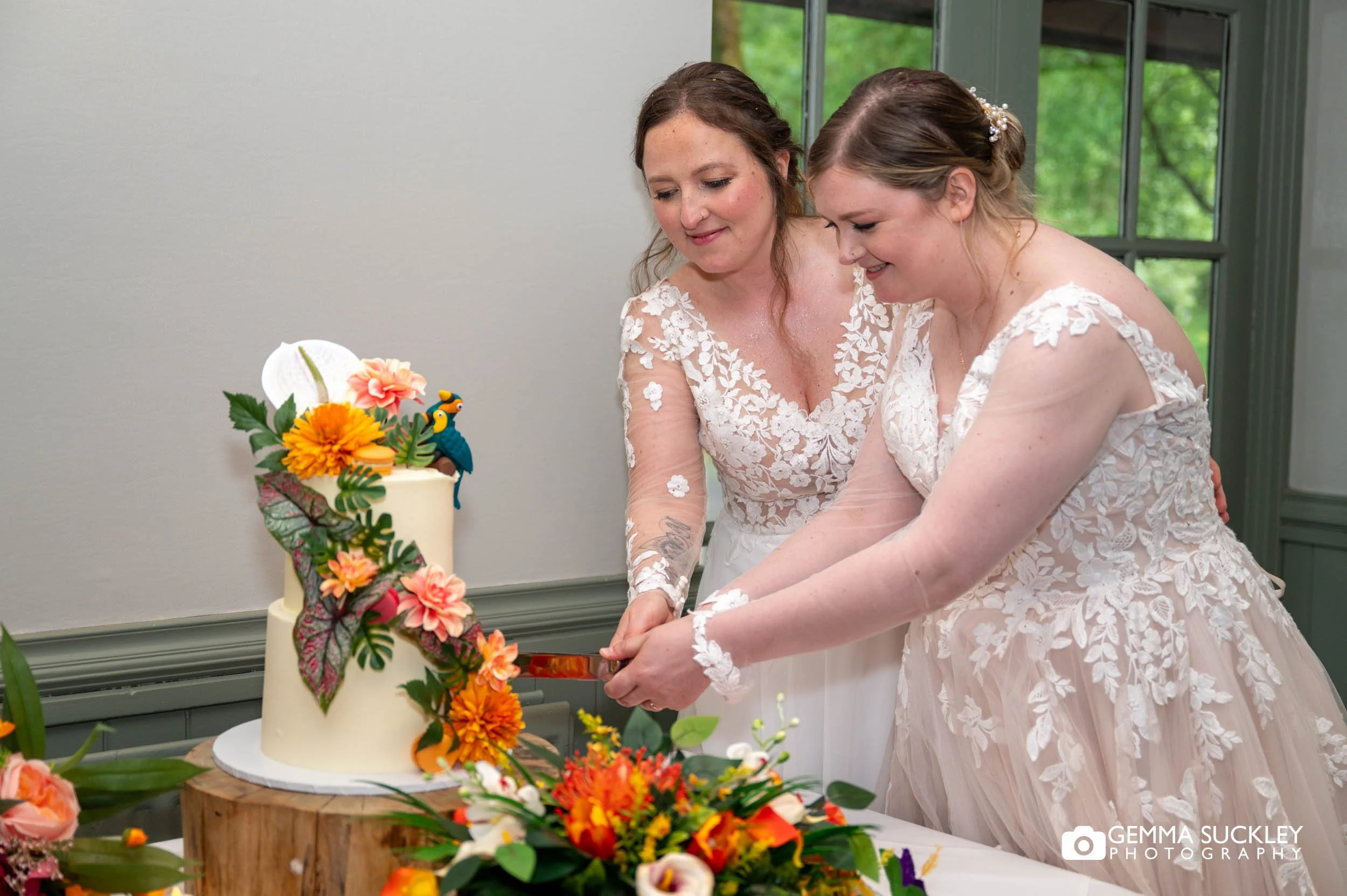 couple cake cutting her colour wedding cake
