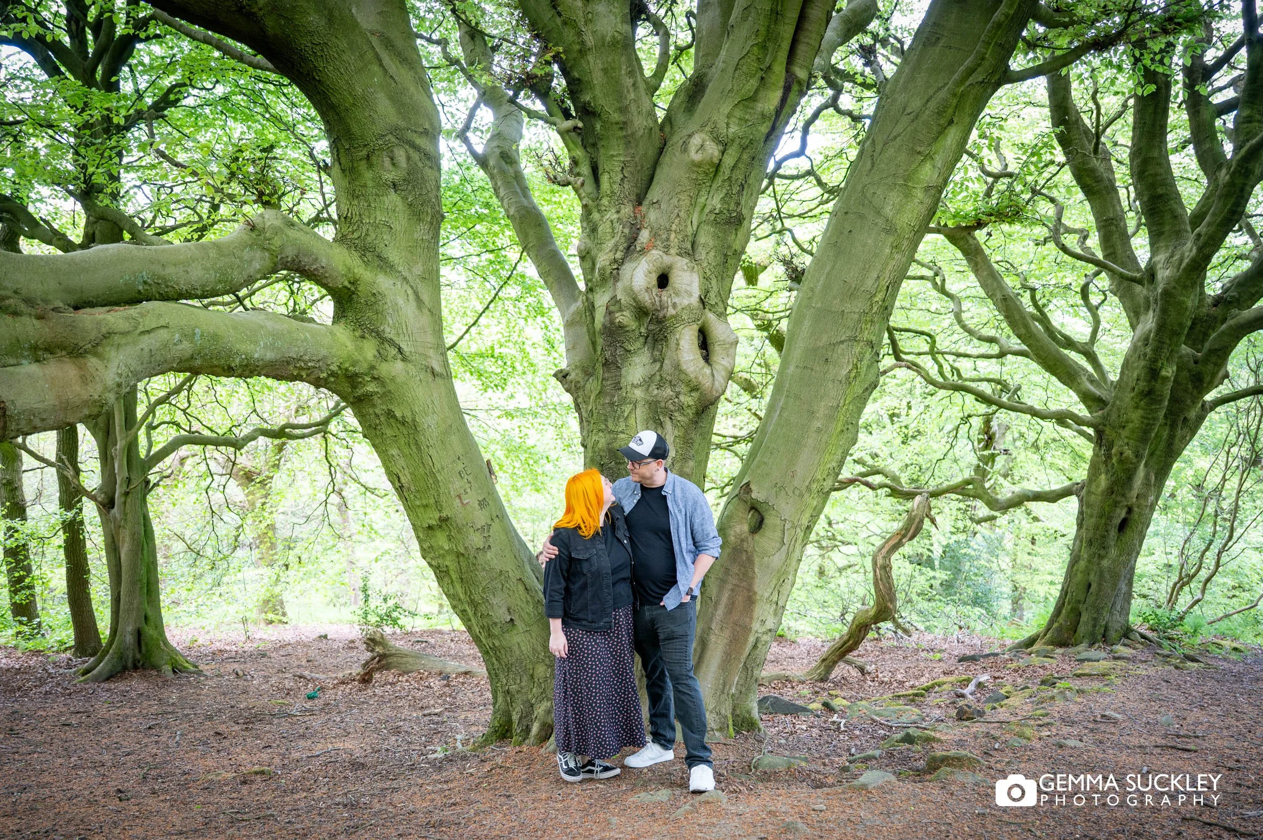 Couple walking hand in hand through woodland