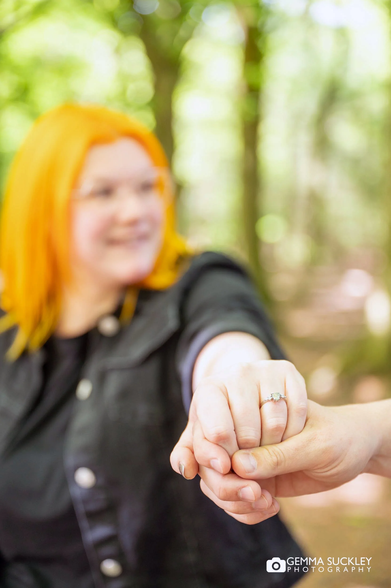 engaged couple holding out the ring