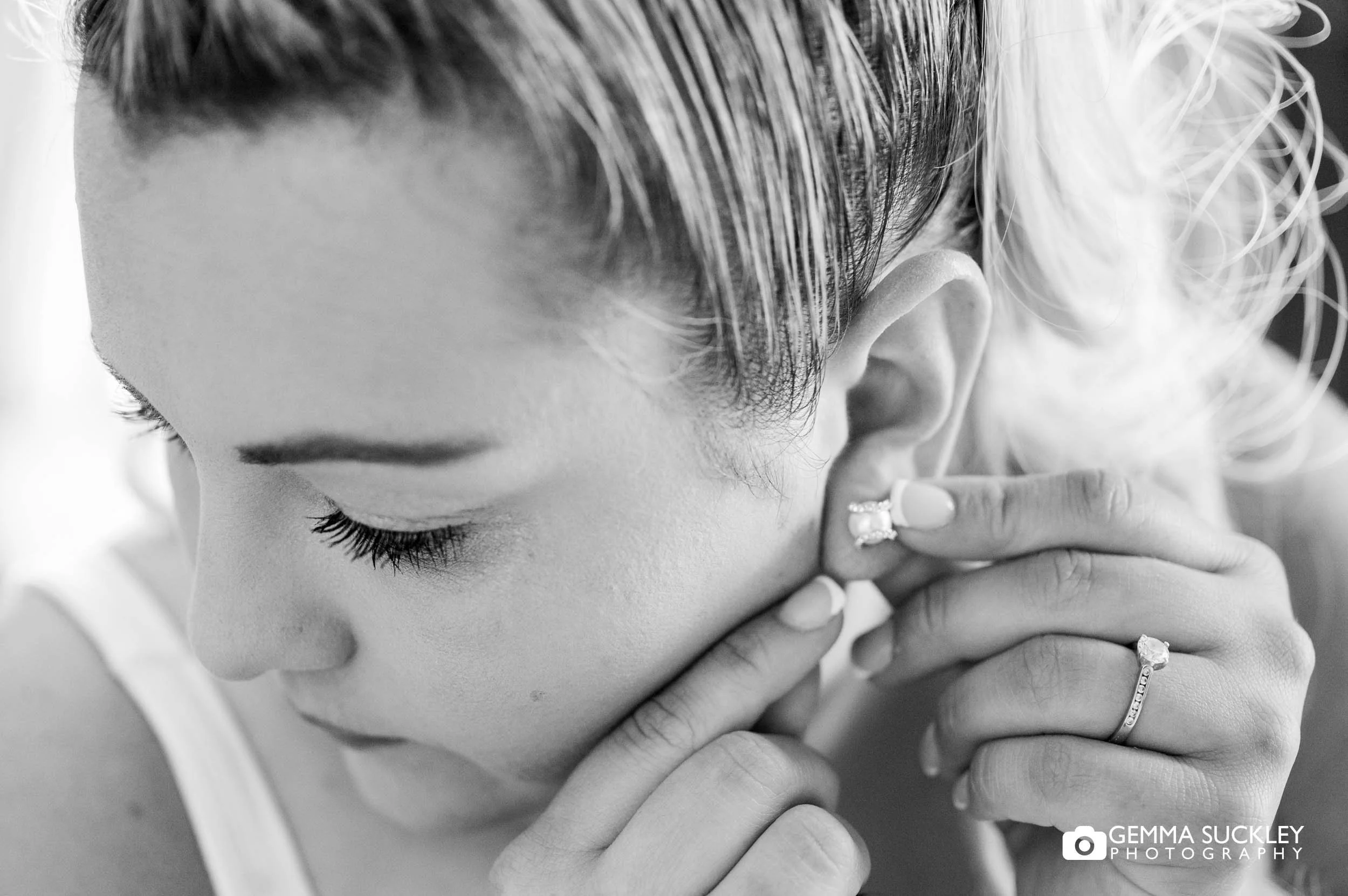 bride putting on jewellery 