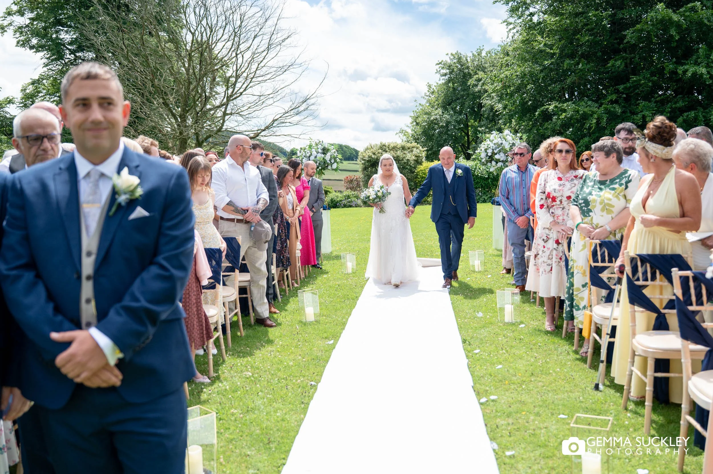 Bride walking down the aisle outside the Falcon Manor