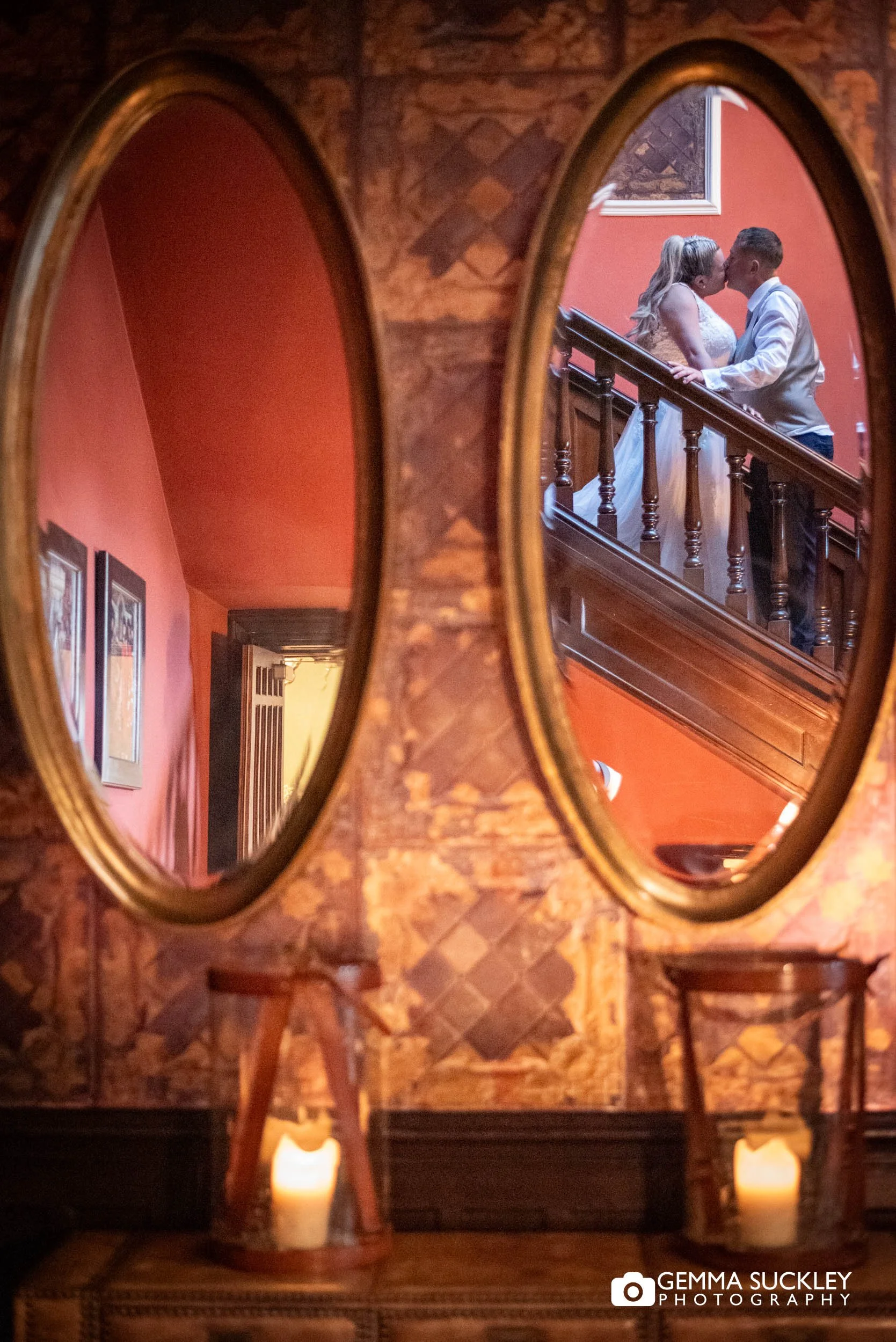 Bride and groom reflected in the mirror on the staircase at Falcon Manor