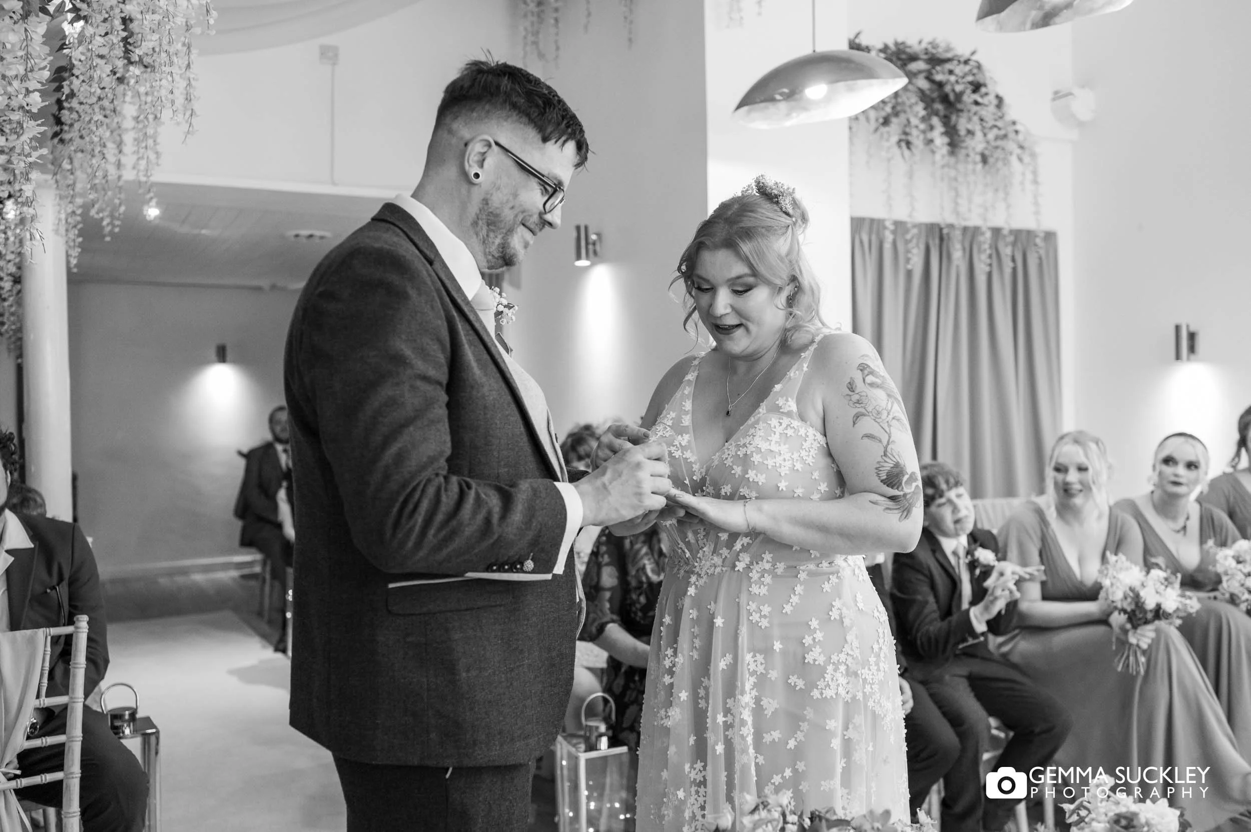 Bride placing the wedding ring on the groom's finger