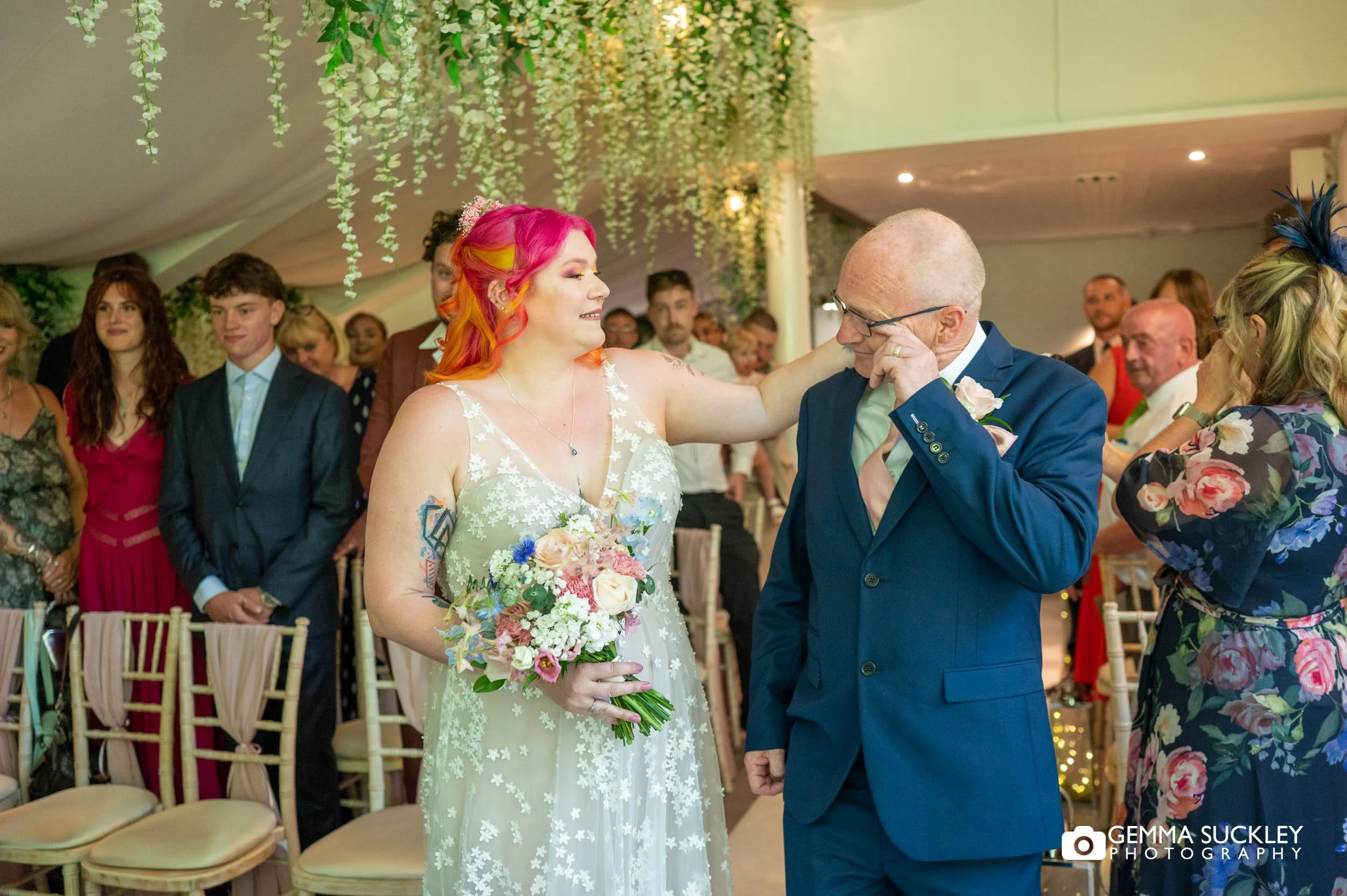 father of the bride wipe away a tear as he hand over the bride