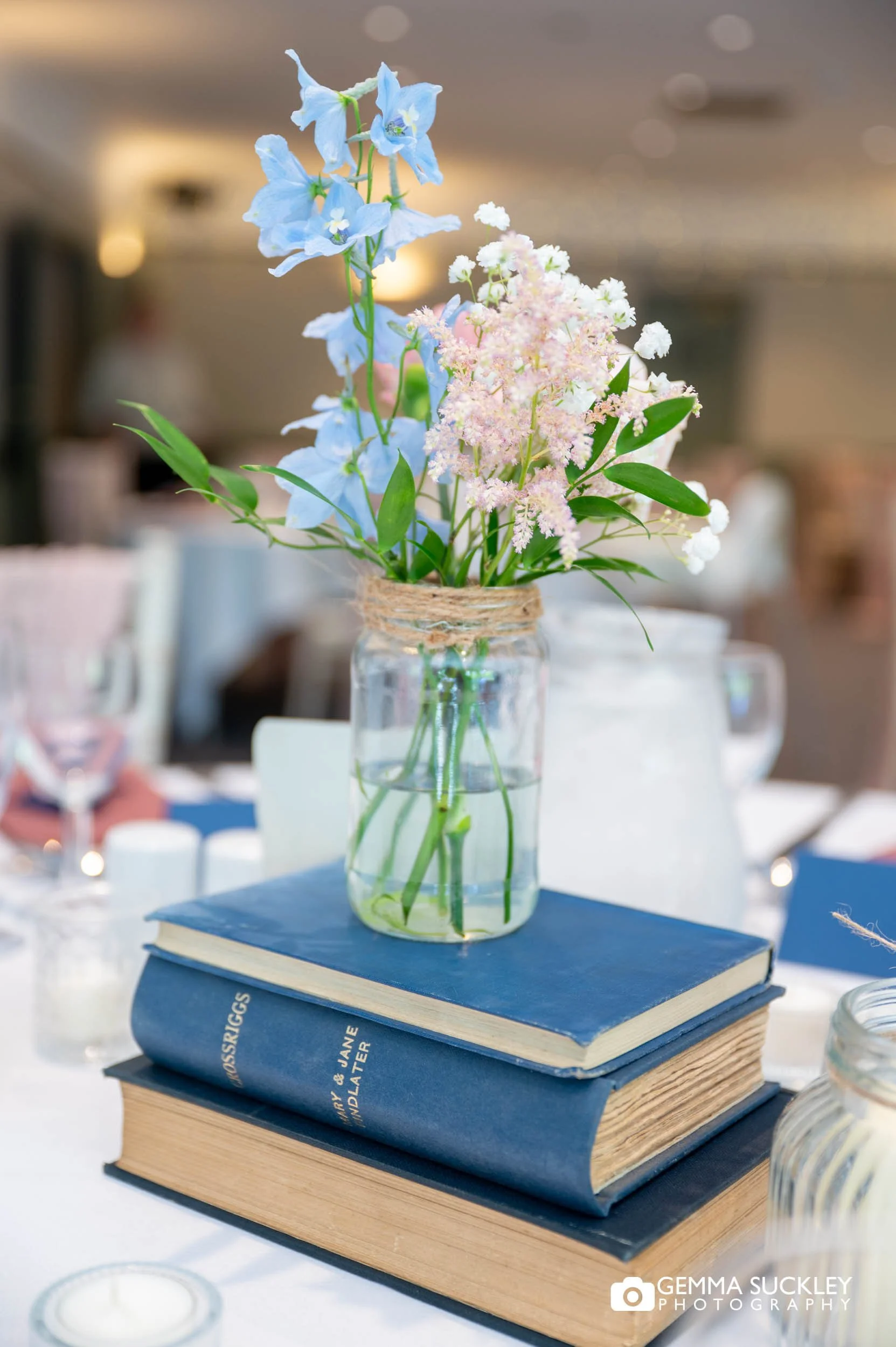 Book-themed wedding table styling with floral centrepieces