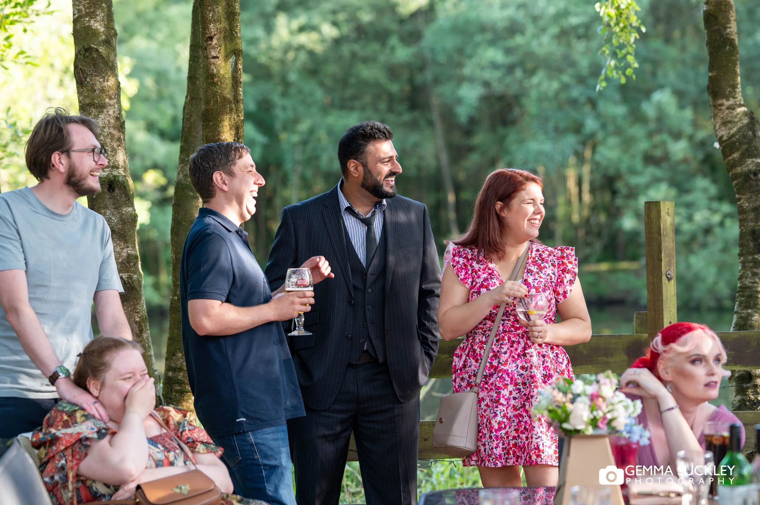 wedding guests laughing in the evening sun
