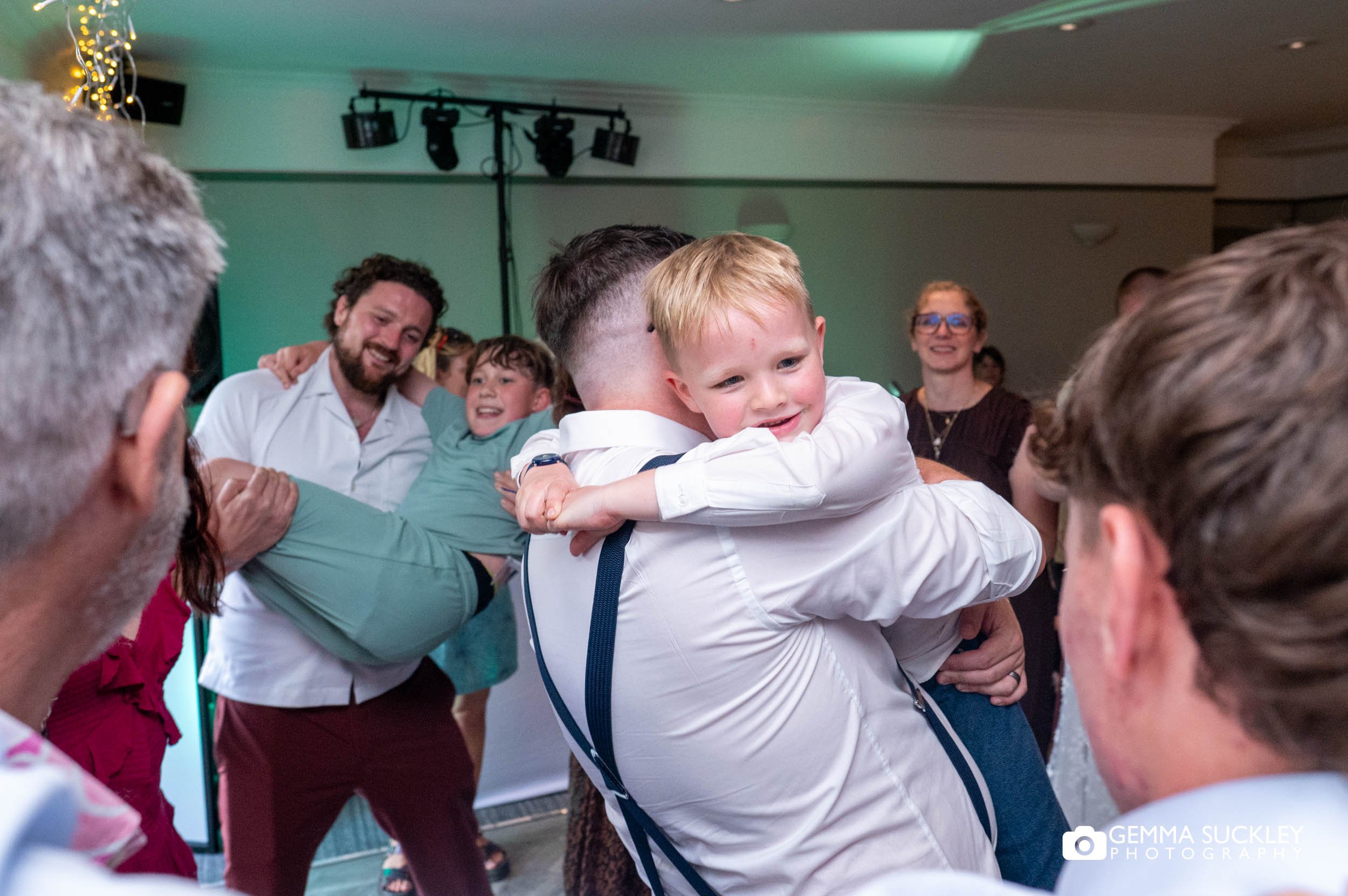 groom hugging his son on the dancefloor