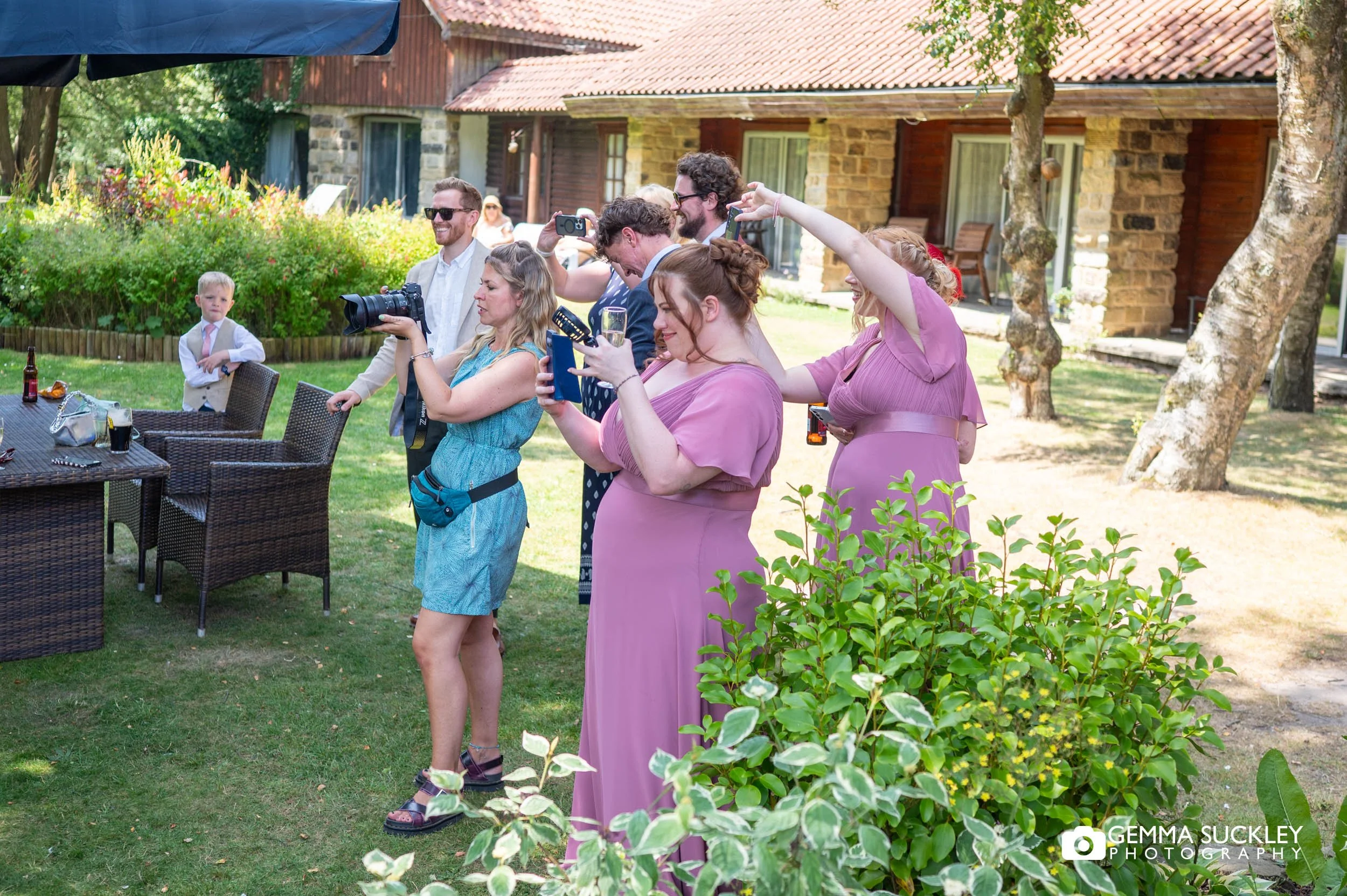 wedding photographer taking photos while guests copy