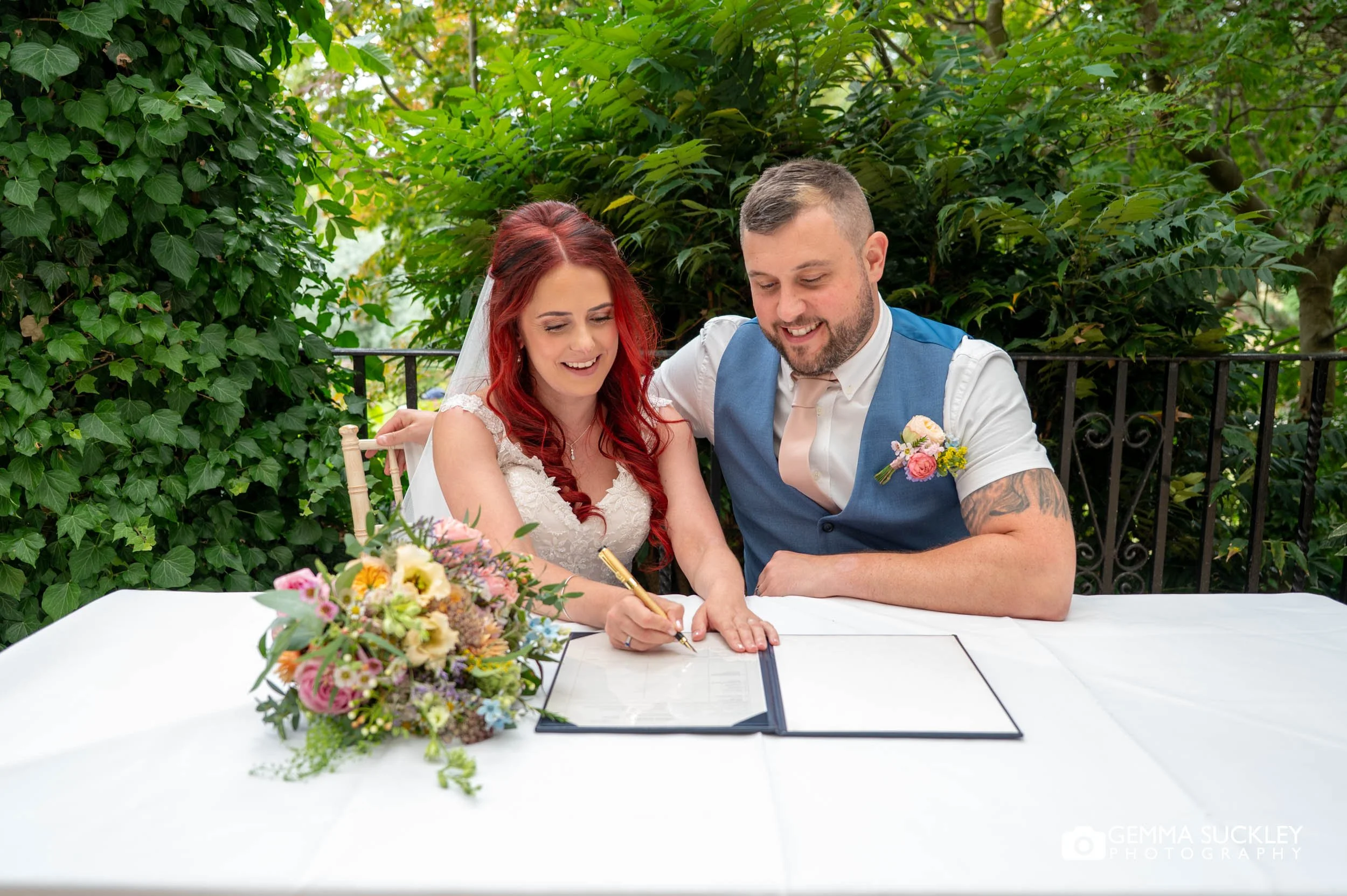 bride and groom signing the register at sun pavilion