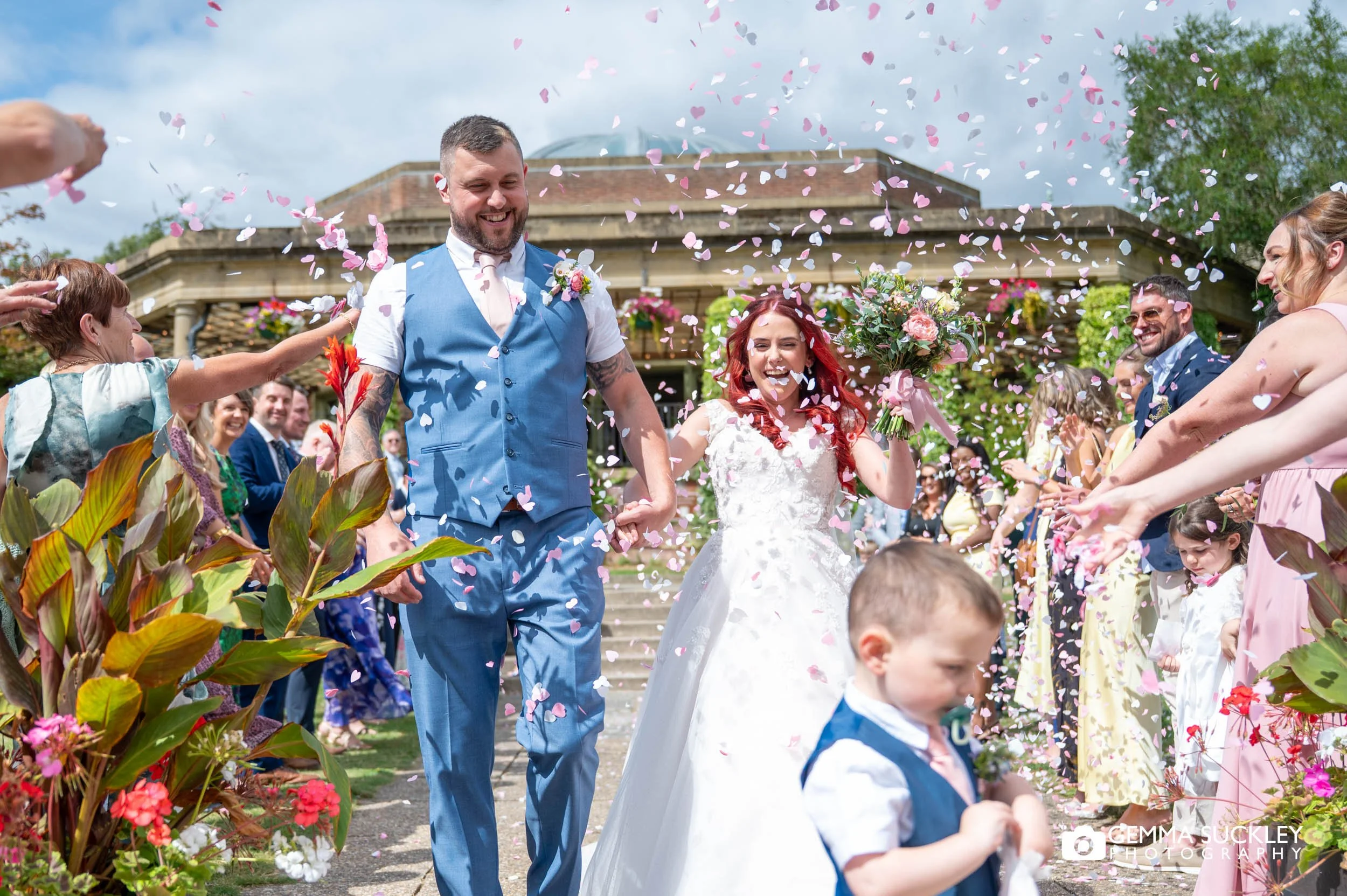 Wedding guests throwing confetti as the newlyweds