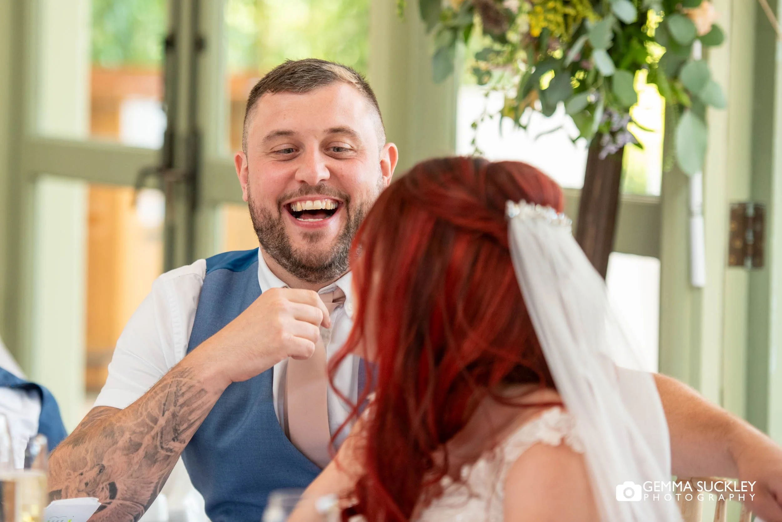Bride and groom listening to a speech during their wedding reception