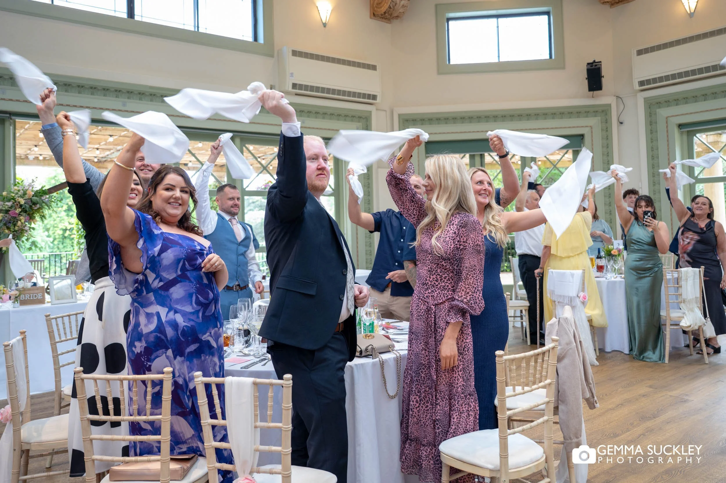 wedding guests waving napkins to welcome the newly-weds