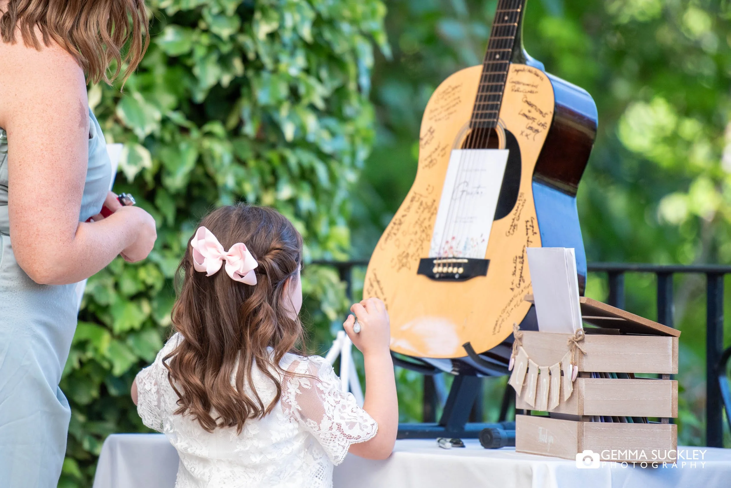 kids signing the Guitar used as a unique wedding guest book