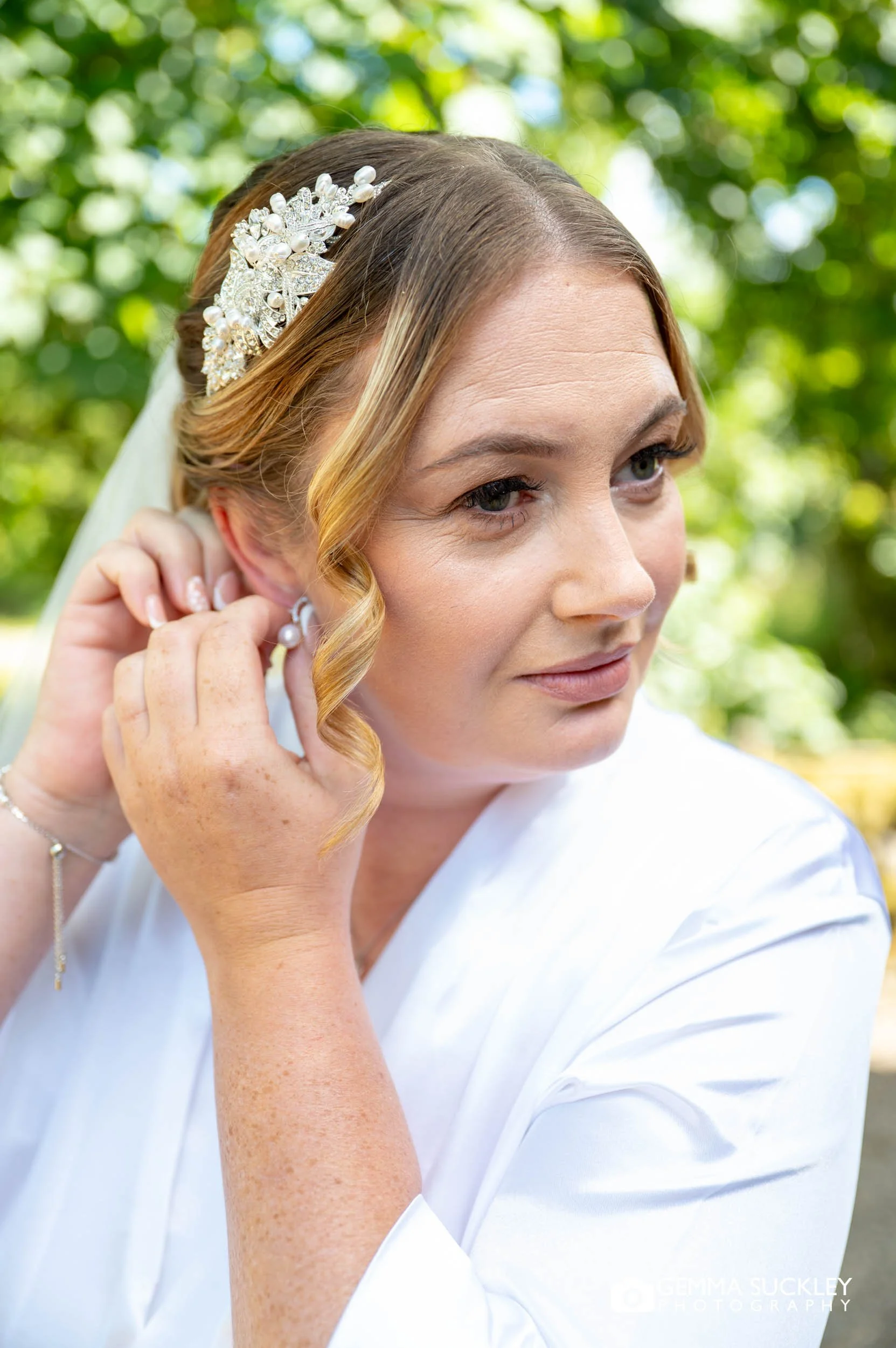 bride putting in ear rings