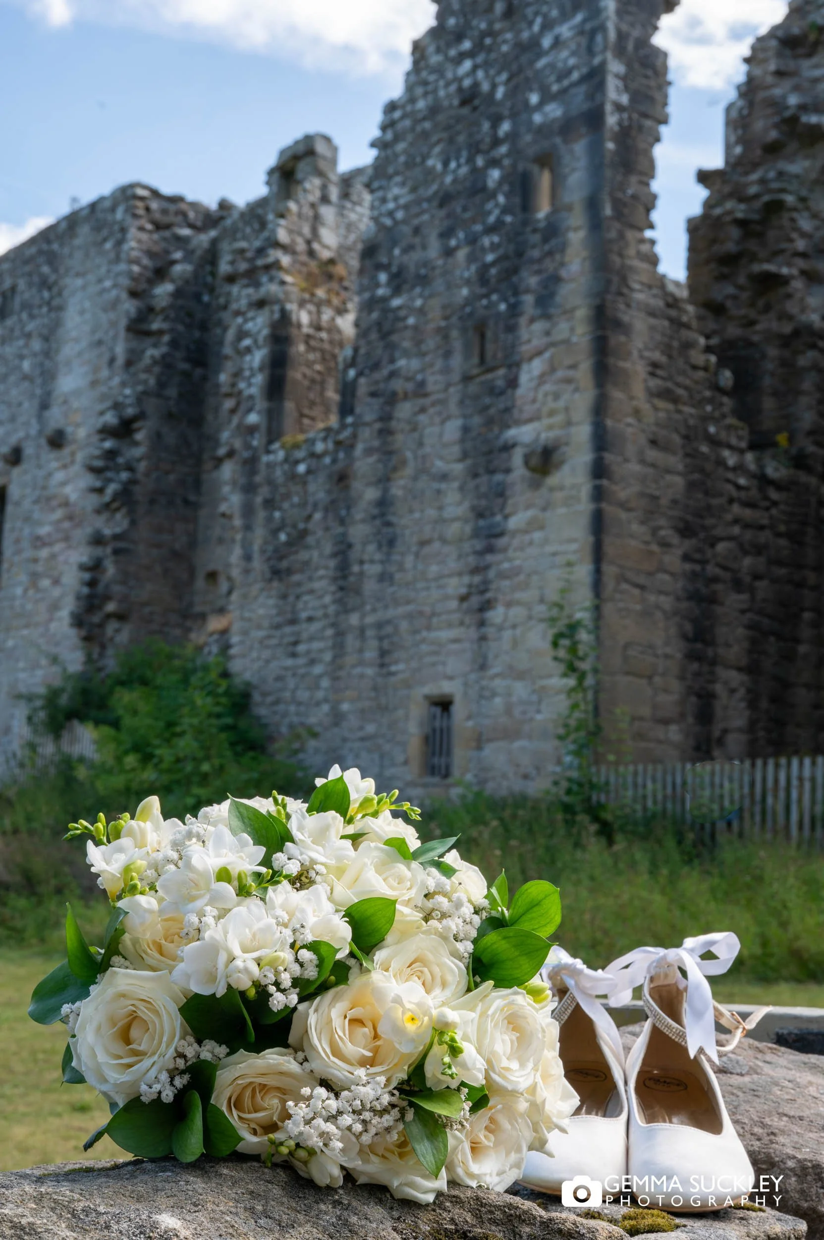 wedding bouquet and shoes in front of barden tower