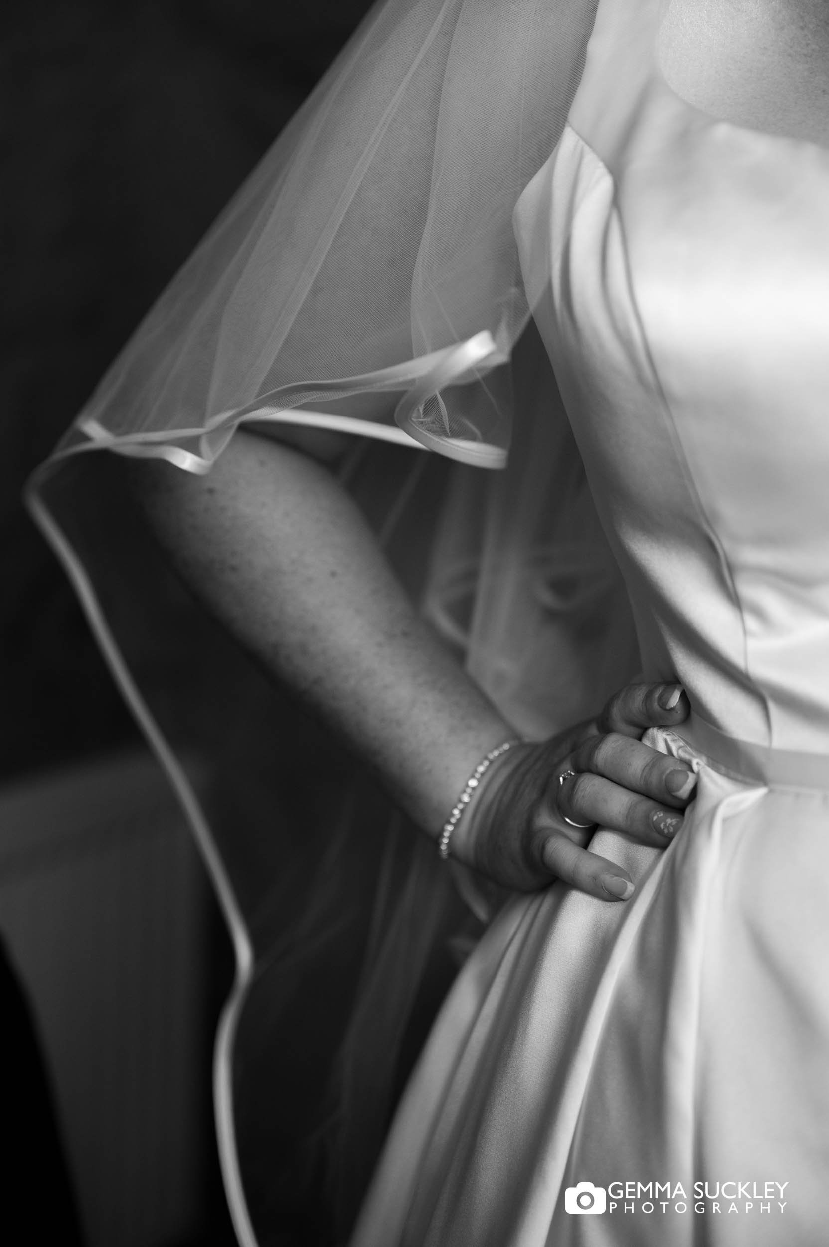 Bride getting ready in her wedding dress, with her veil visible