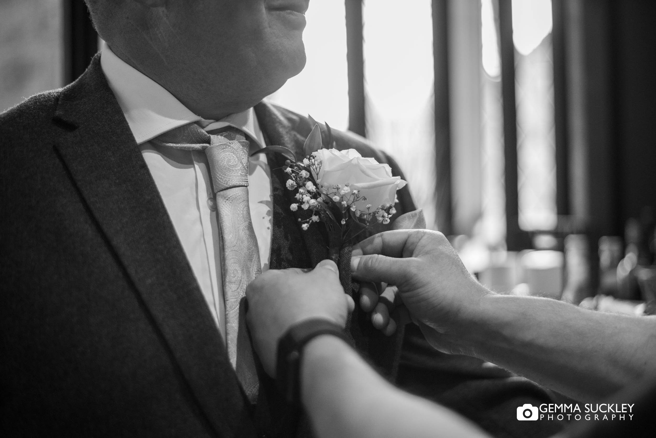 groom putting on his button hole
