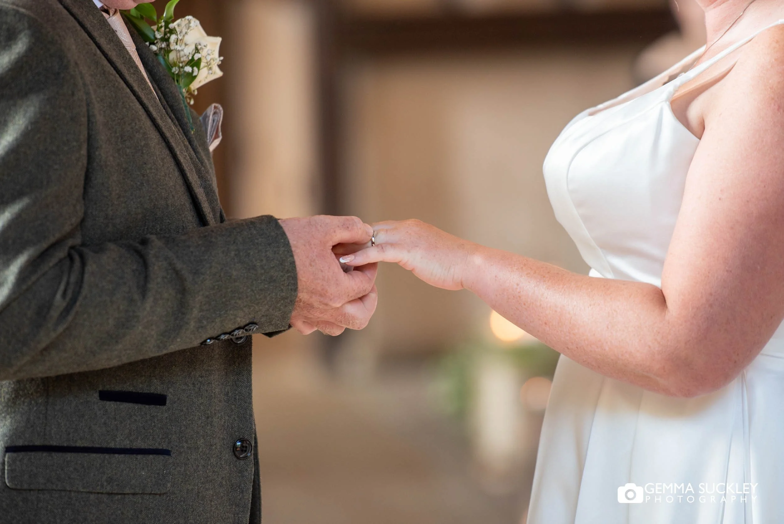 groom putting on the brides wedding ring