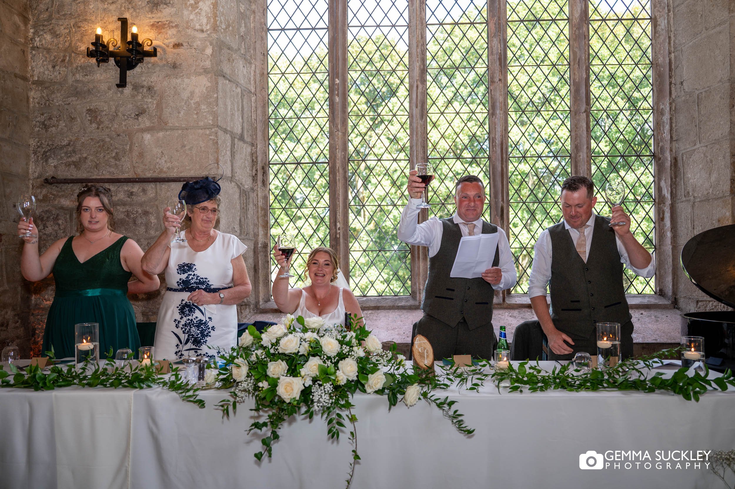 the bride and grooms party toasting during speeches