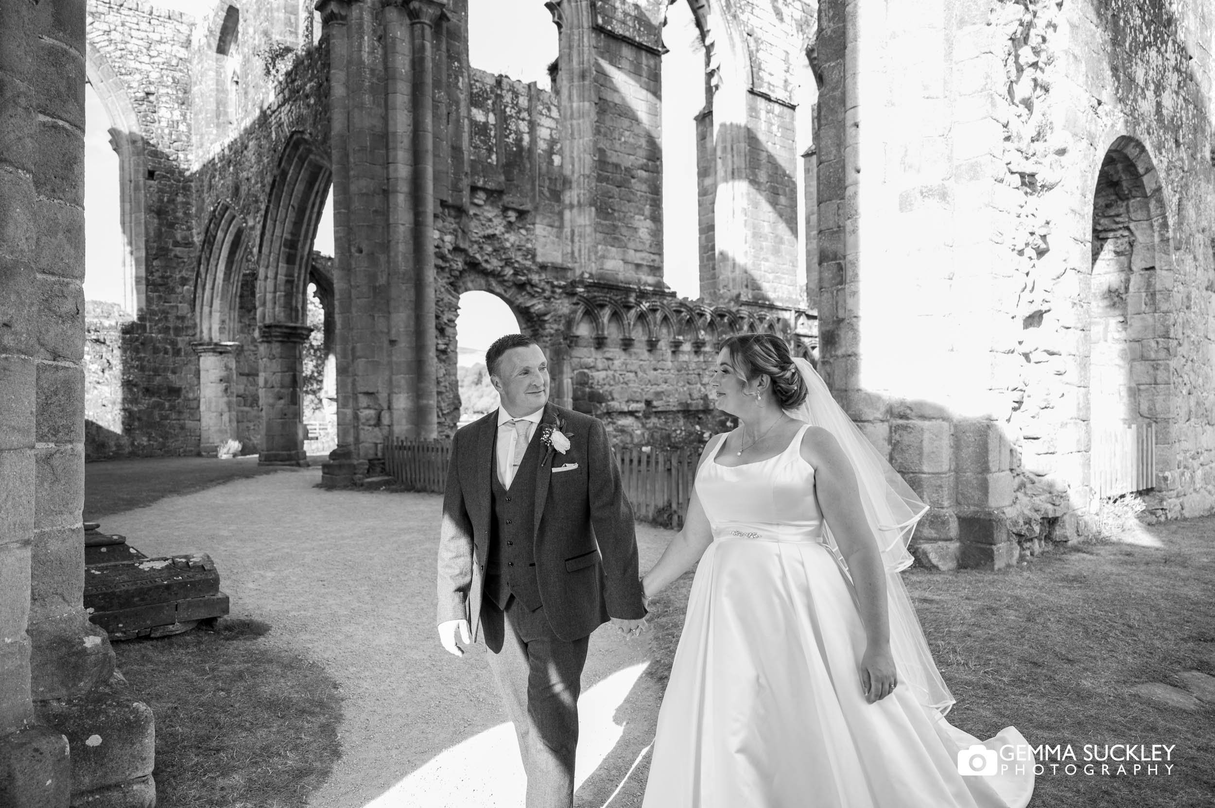 Bride and groom at Bolton Abbey after their wedding ceremony Bride and groom exploring Bolton Abbey ruins