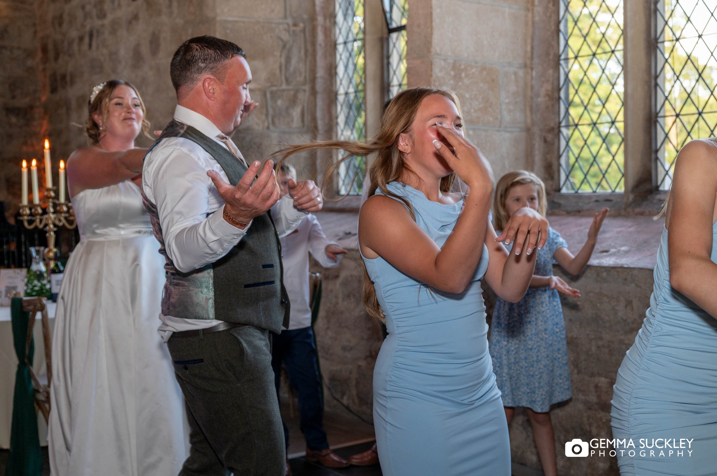 bride and groom with wedding guests on the dance floor