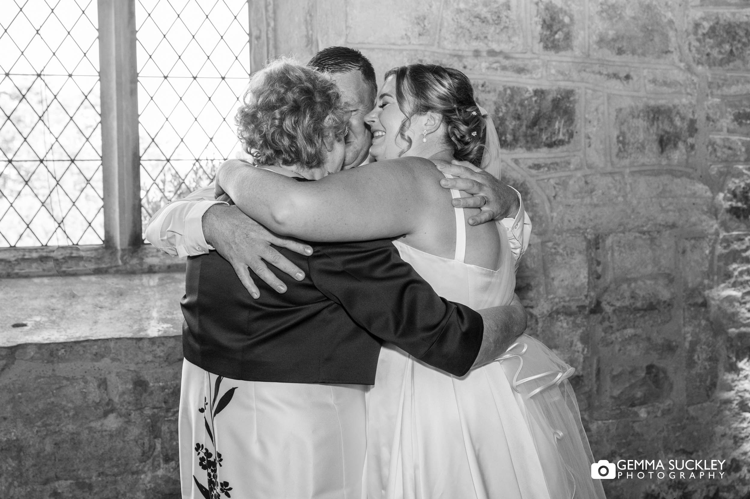 bride and groom hugging her mum