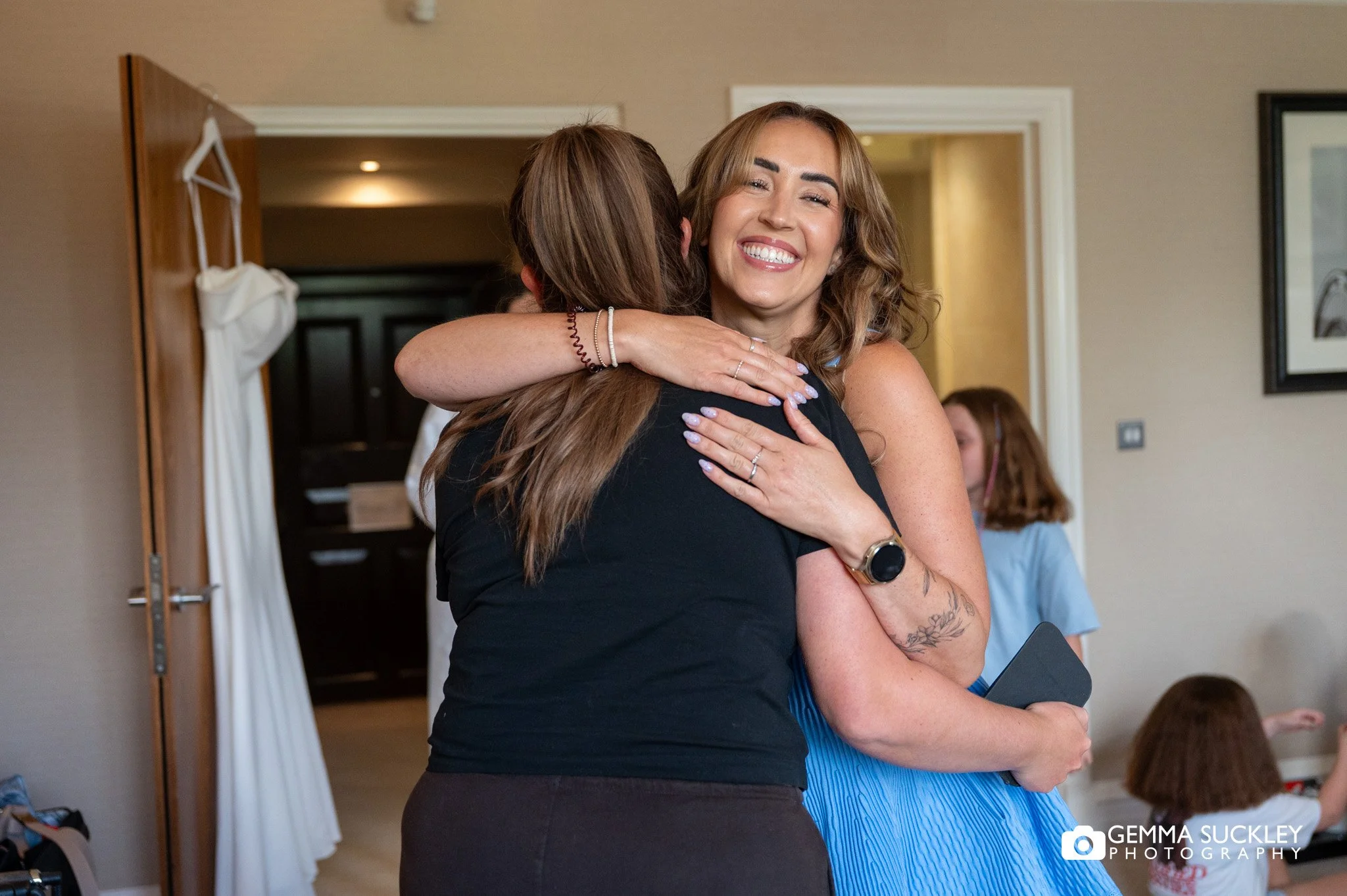 bridesmaid hugging the hair dresser