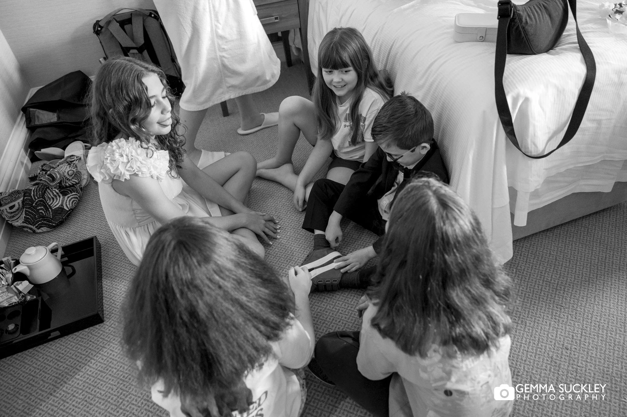 kids sitting on the floor while the adult get ready