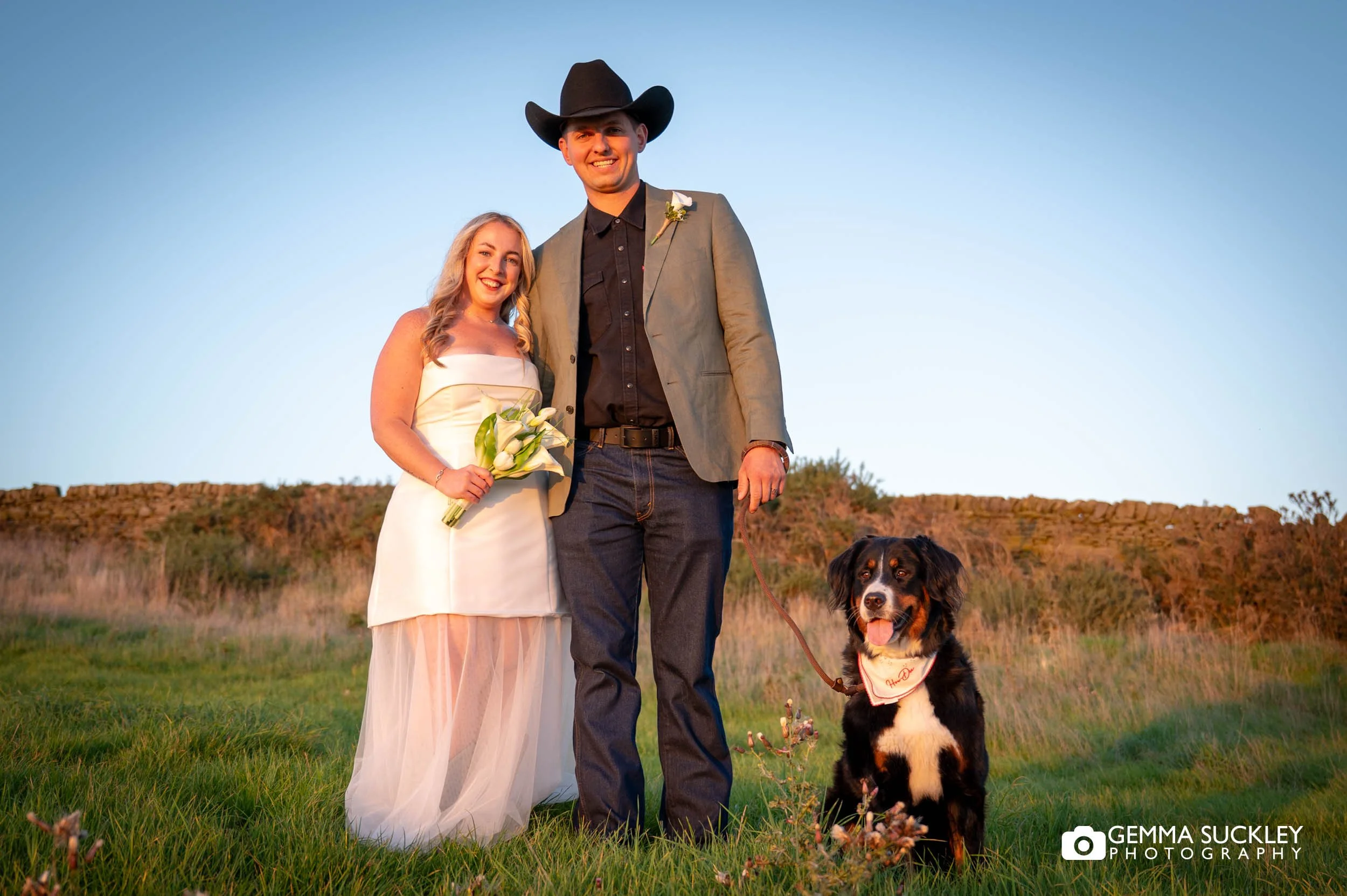 married couple with their dog at sunset