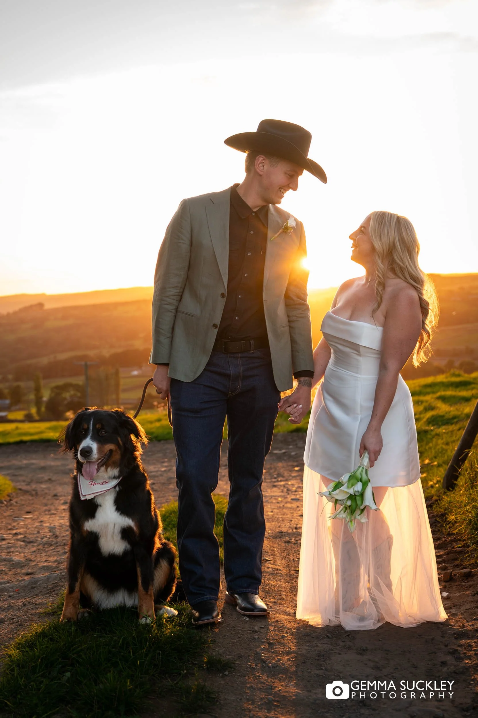 bride and groom at sunset with their dog