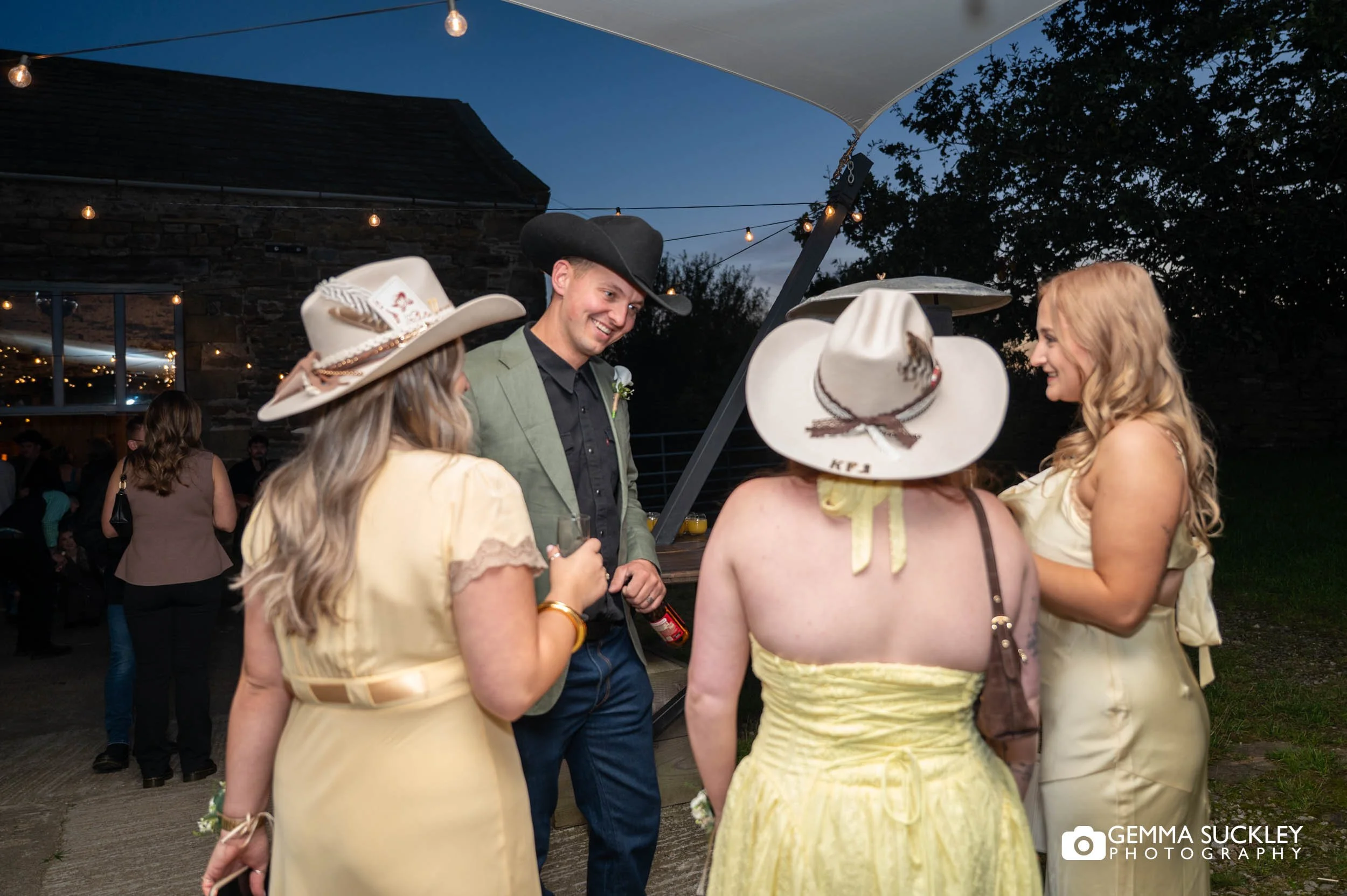 groom and bridesmaid in their cowboy hats