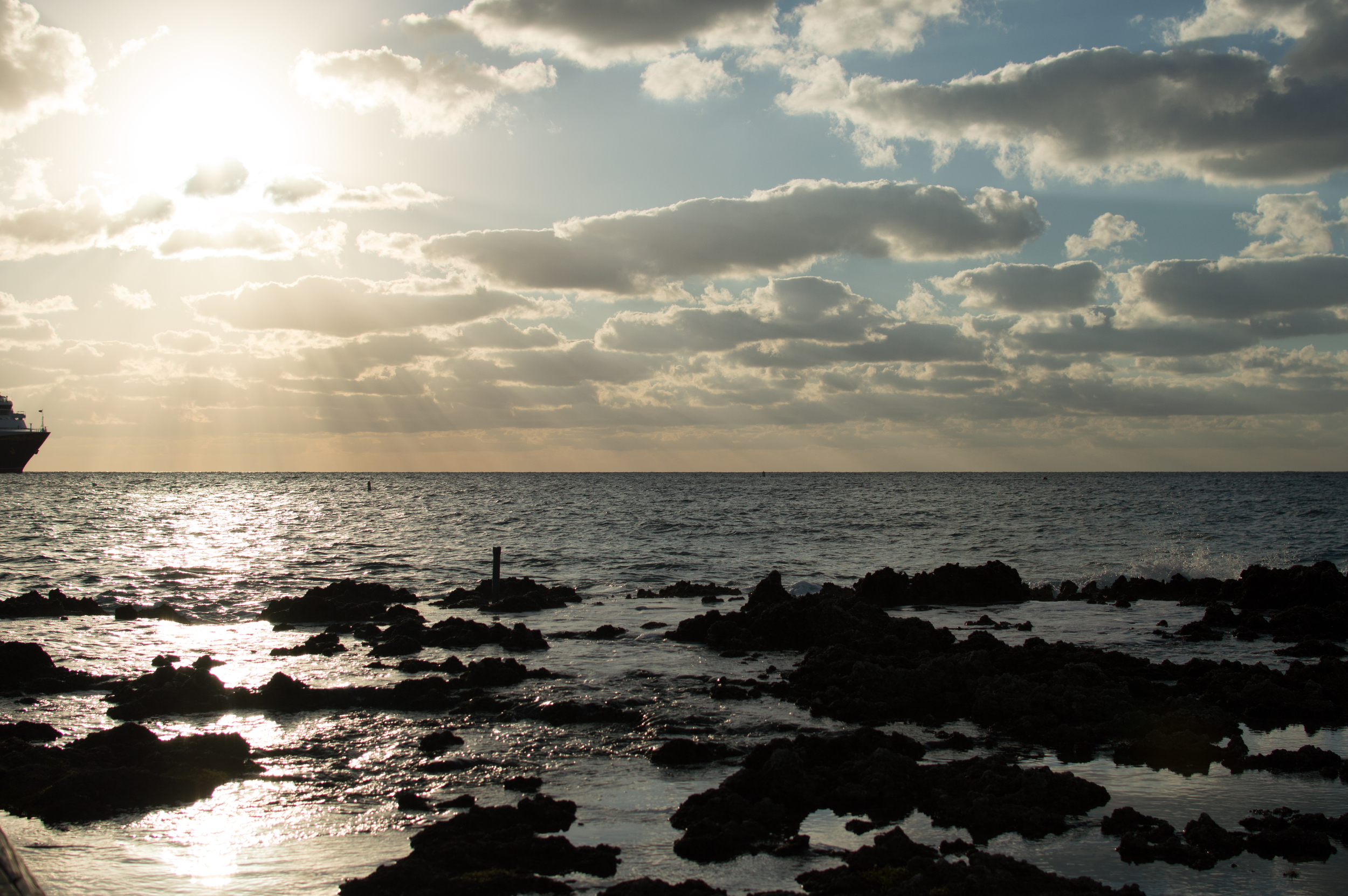 Watching the cruise ships leave from a dock surrounded by rocks and waves.