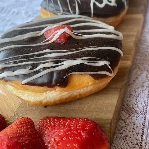 Sweet donuts made with love are perfect for February's feature donut.  These fluffy donuts are stuffed with strawberry filling, then topped with chocolate and finished with drizzled white fondant and a berry.  Pondering what to get for your Valentine