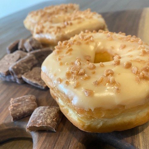 We are basking in summer sweet tooth vibes for our feature donut in June. This decadent treat features a soft, fluffy dough smothered in caramel flavoured vanilla fondant and topped with crunchy, buttery Skor bits.  An amazing mix of texture and flav