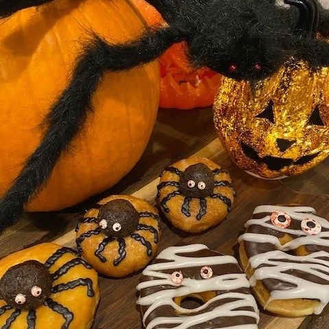 Only treats, no tricks on October 31st. Donut be scared (like the donuts picture here)! Halloween donuts are available as a 'mummy" or with our "spider" (chocolate cake mill bite) sitting on top of a vanilla cake donut OR yeast donut. 