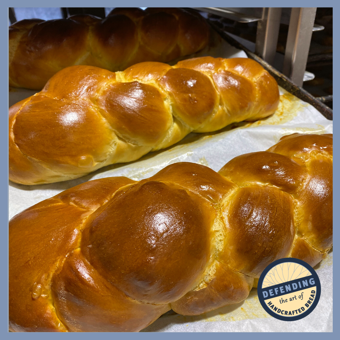 A group of challah bread loaves sitting on a baking sheet