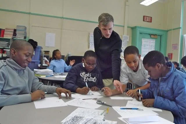 James Hobin reviewing artwork with students at the Nathan Hale School on Fort Hill in Roxbury.