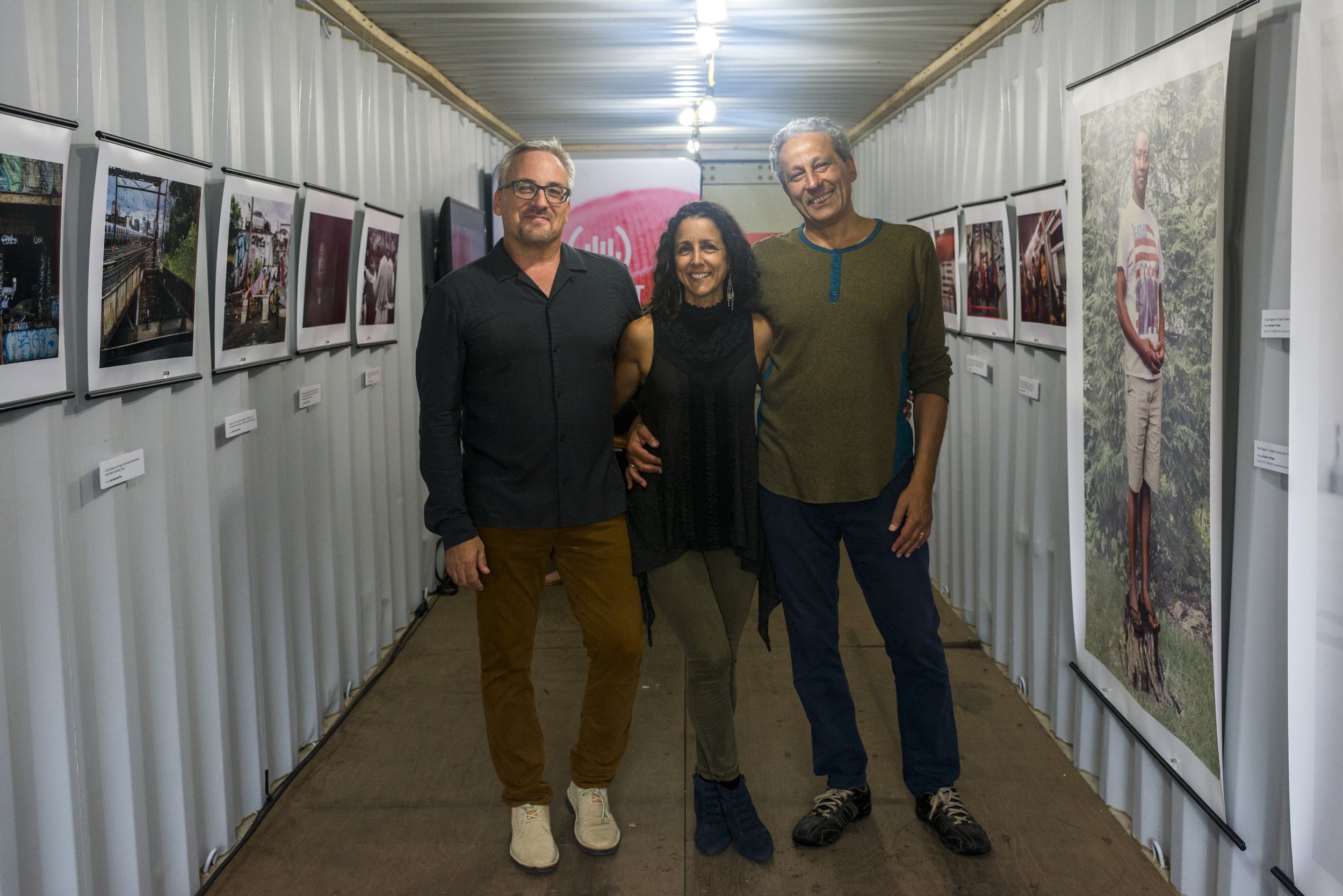  Newest Americans partners Tim Raphael, Julie Winokur, and Ed Kashi smile for the camera in our container exhibit. (Photo by Gareth Smit) 