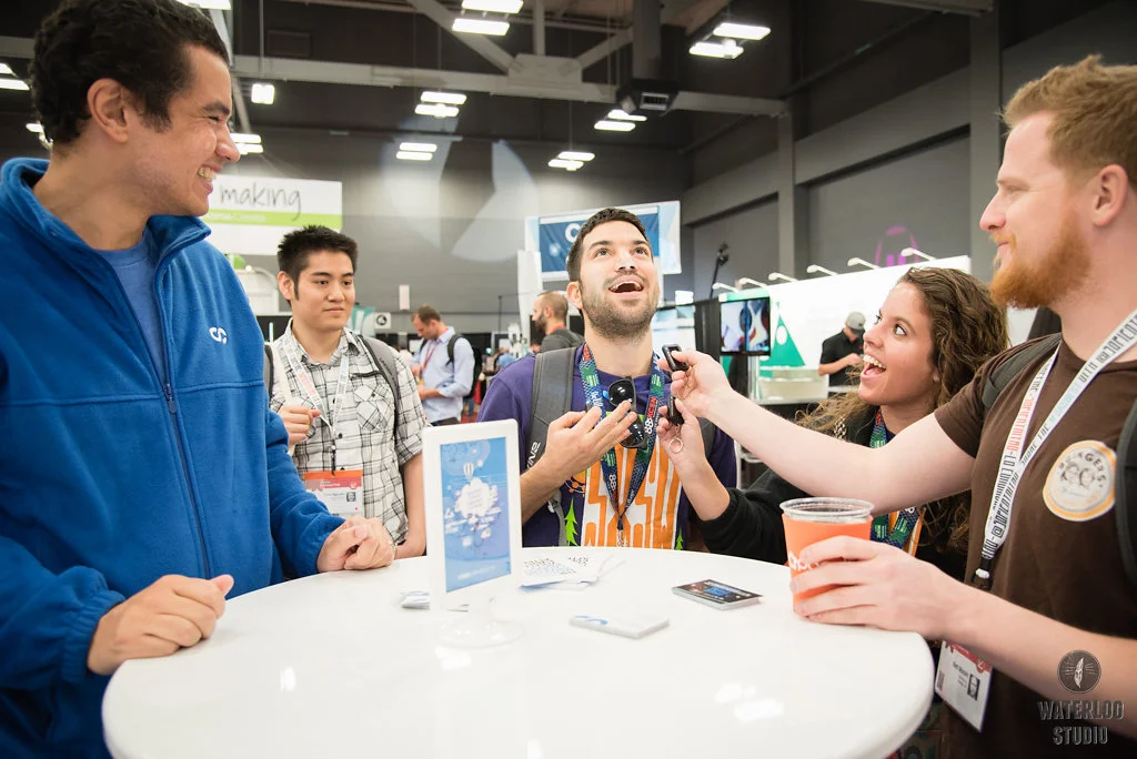 Attendees having fun at the booth and getting really excited about the StockUnlimited solar powered flashlight giveaway.&nbsp;