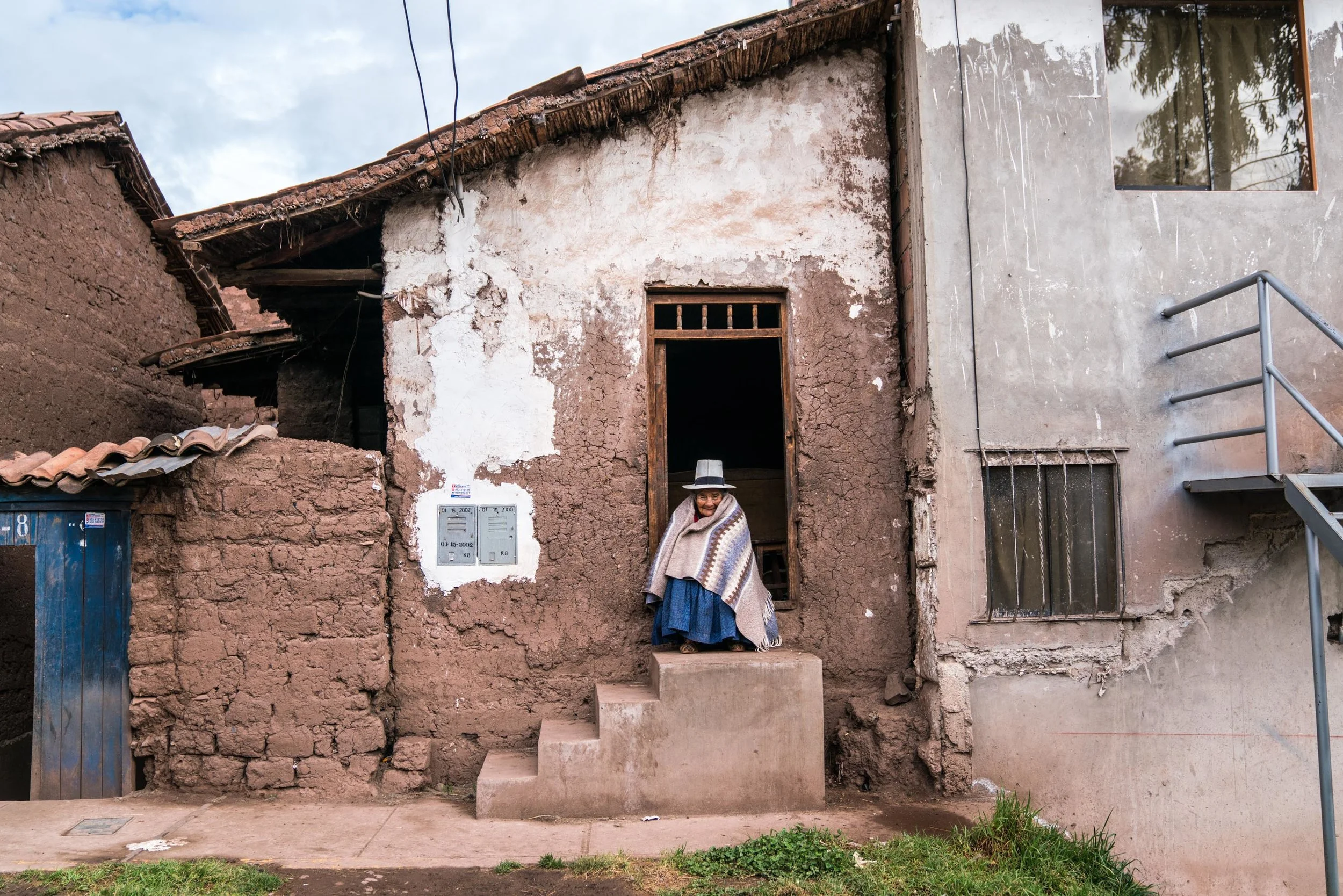 Woman sits on her home's door step