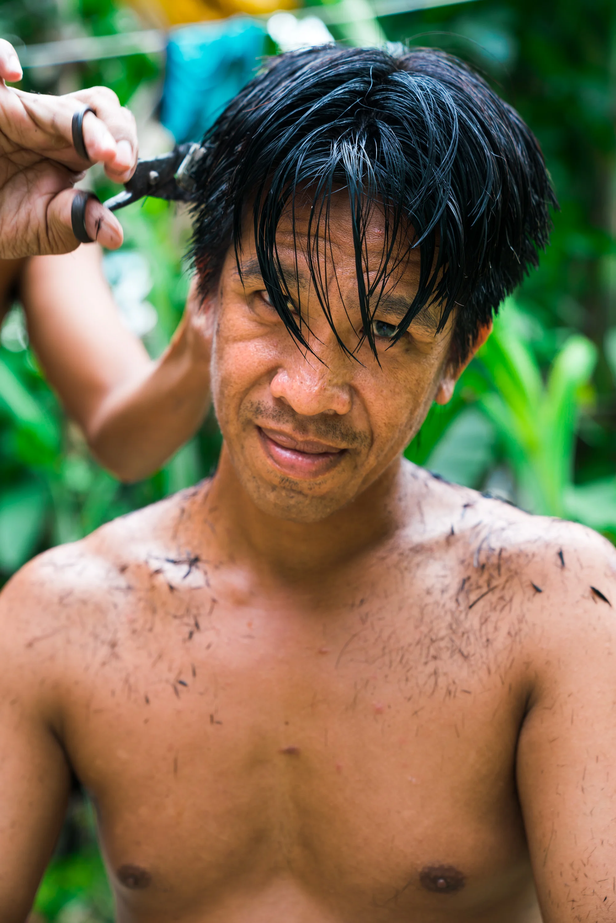 I saw this scene unfolding through the jungle foliage, I walked over to find a man cutting another’s hair in their back yard. They saw me and gestured to come over. For about 10 minuets I witnessed them chatting before capturing this portrait. Port Barton, Palawan. Philippines, 2018.