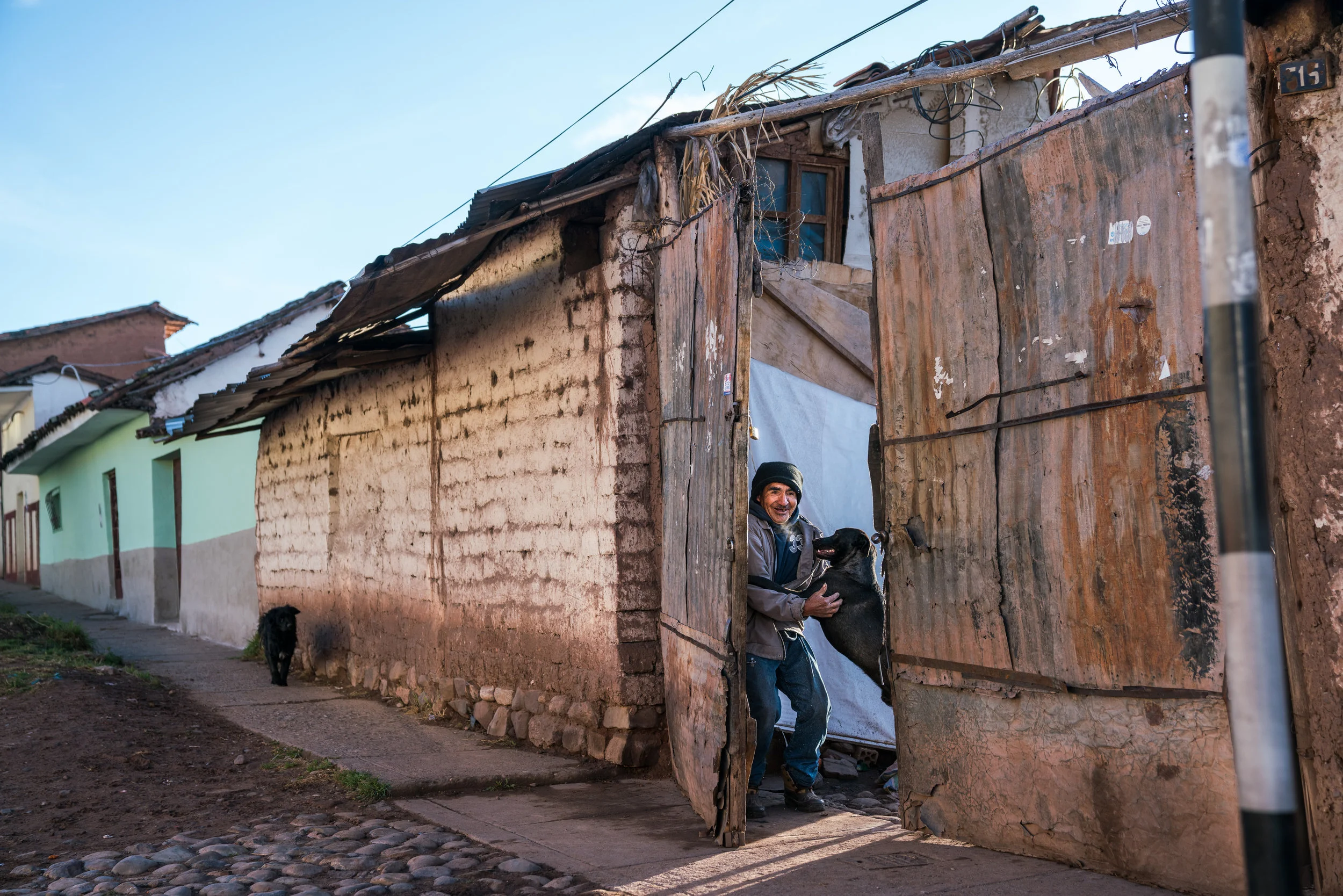 Man stops his dog from escaping. Cusco, Peru. 2018