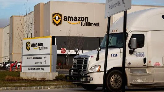 A truck drives past the Amazon.com fulfillment center in Robbinsville, New Jersey, Nov. 30, 2015. Michael Nagle | Bloomberg | Getty Images