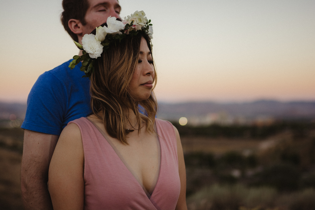 Husband and wife embracing each other on a hill in Keystone Canyon